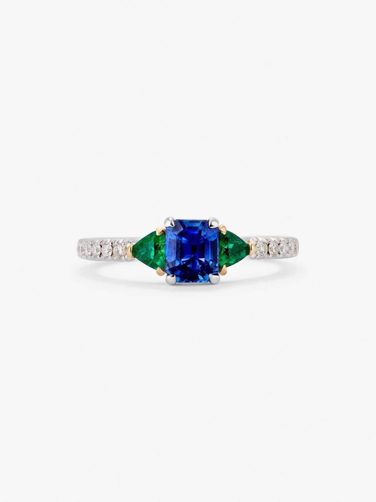 Anillo de oro blanco de 18K con zafiro azul en talla octogonal de 0,94 cts, esmeraldas verdes en talla trillon de 0,22 cts y diamantes blancos en talla brillante de 0,028 cts