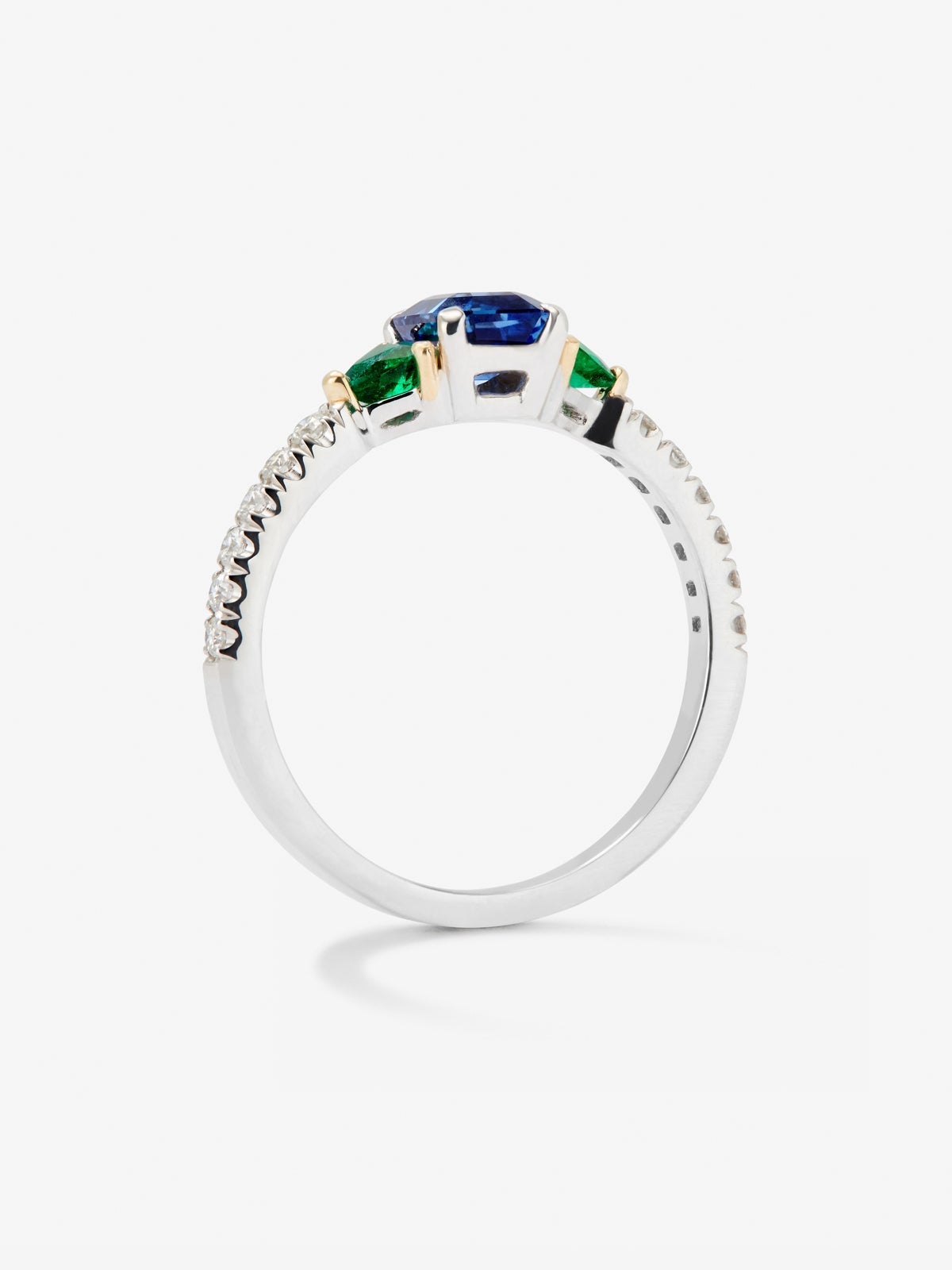 Anillo de oro blanco de 18K con zafiro azul en talla octogonal de 0,94 cts, esmeraldas verdes en talla trillon de 0,22 cts y diamantes blancos en talla brillante de 0,028 cts