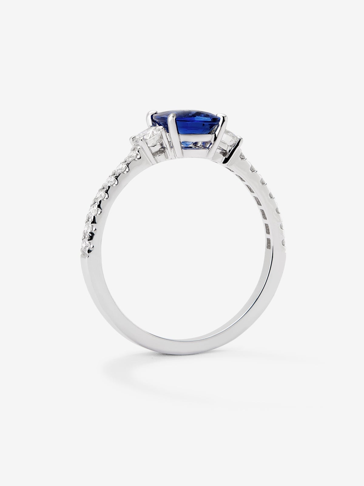 Anillo tresillo de oro blanco de 18K con zafiro azul royal en talla cushion de 1,15 cts y diamantes en talla brillante con un total de 0,37 cts