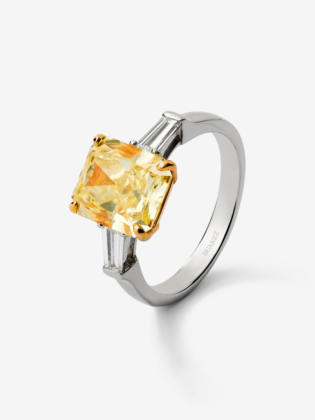 Anillo solitario de oro blanco de 18K con diamante Fancy Yellow en talla esmeralda de 4 cts y 2 diamantes talla trapecio con un total de 0,4 cts 