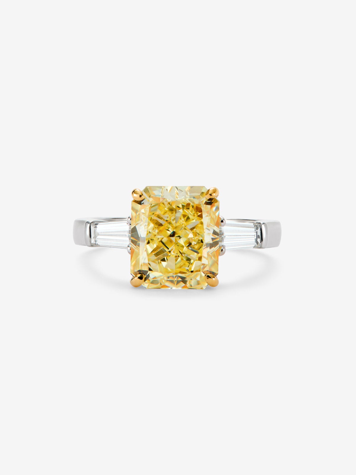 Anillo solitario de oro blanco de 18K con diamante Fancy Yellow en talla esmeralda de 4 cts y 2 diamantes talla trapecio con un total de 0,4 cts 