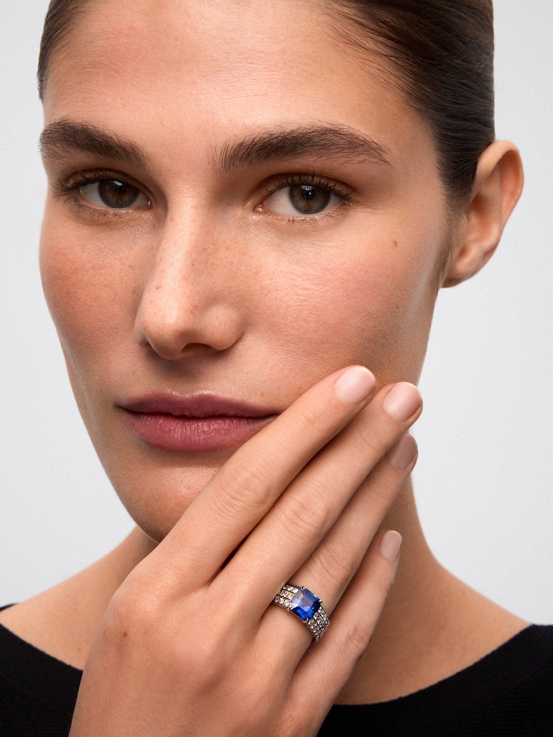 White gold ring with central sapphire and diamond arm
