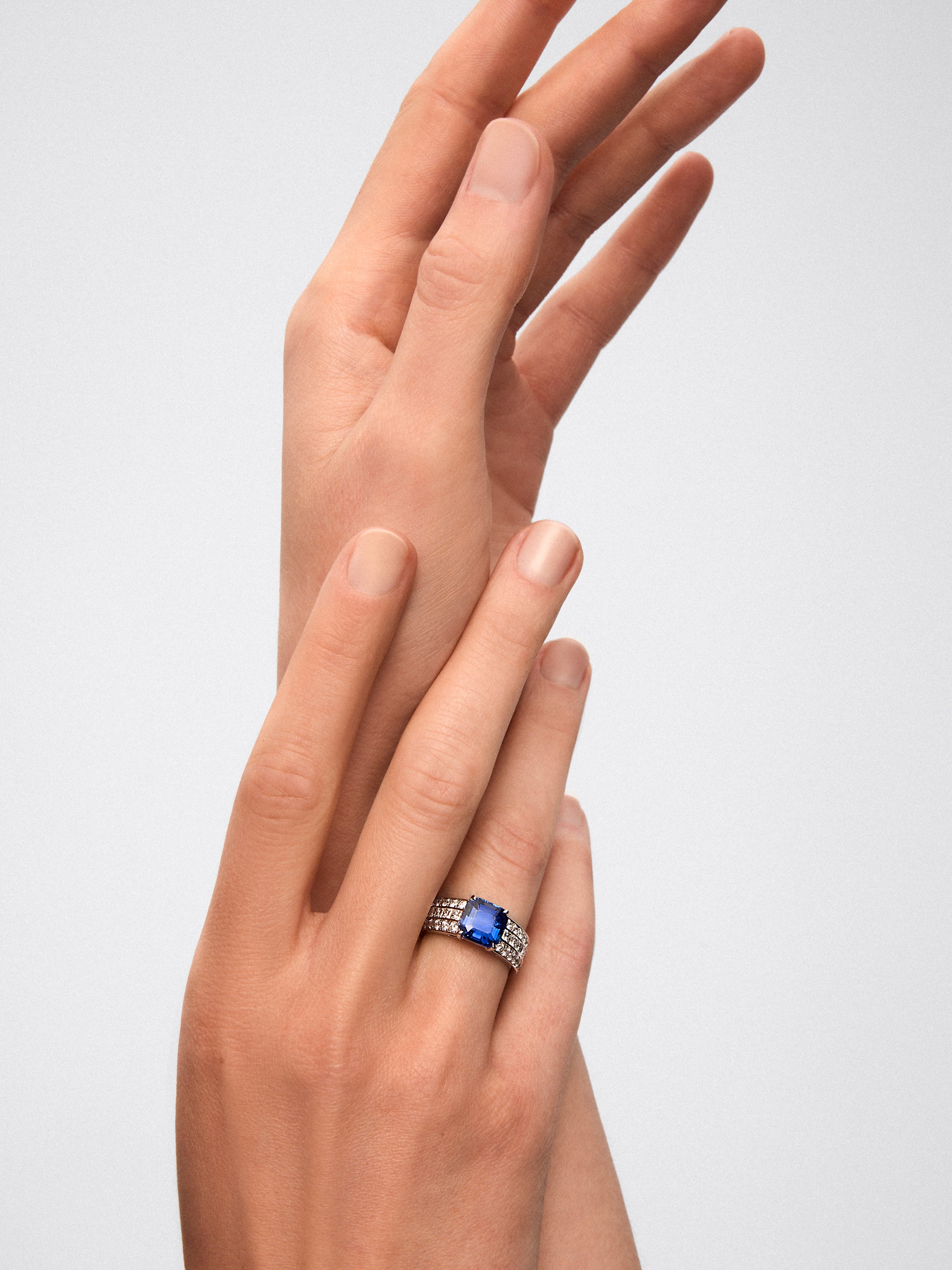 White gold ring with central sapphire and diamond arm