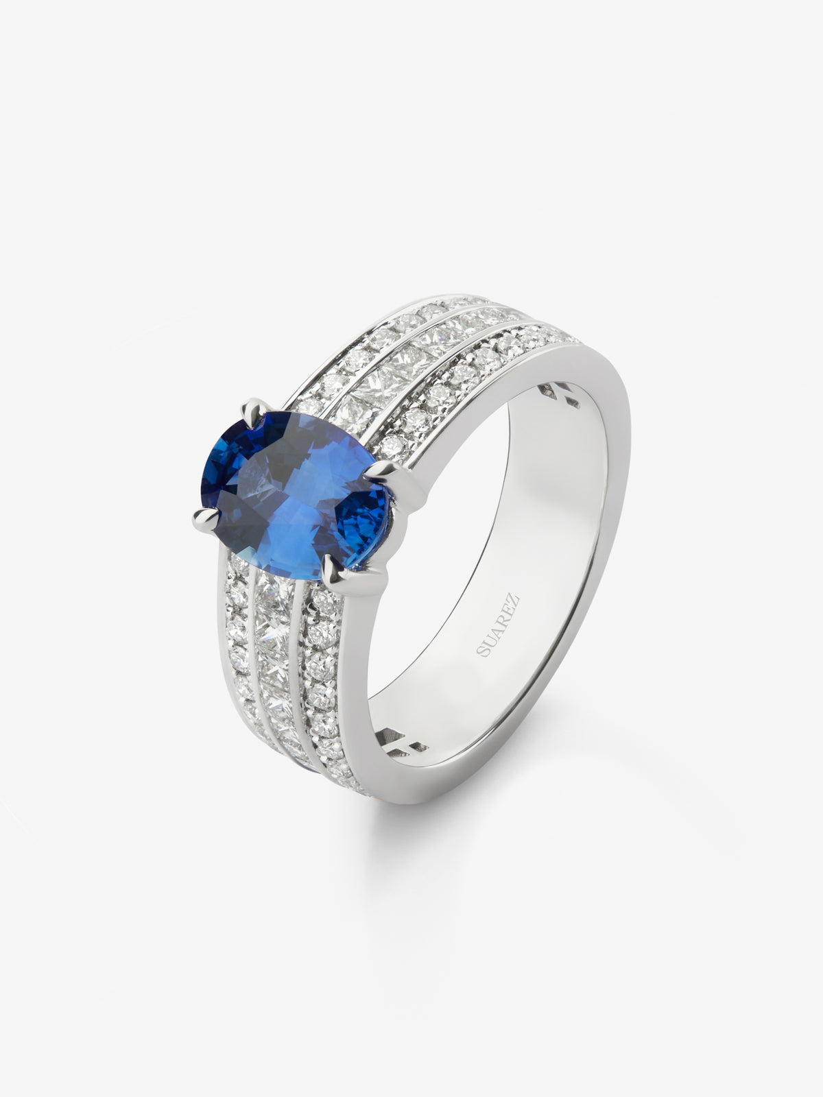 Anillo de oro blanco de 18K con zafiro azul royal en talla oval de 3,75 cts y diamantes en talla brillante y princesa con un total de 1,6 cts 