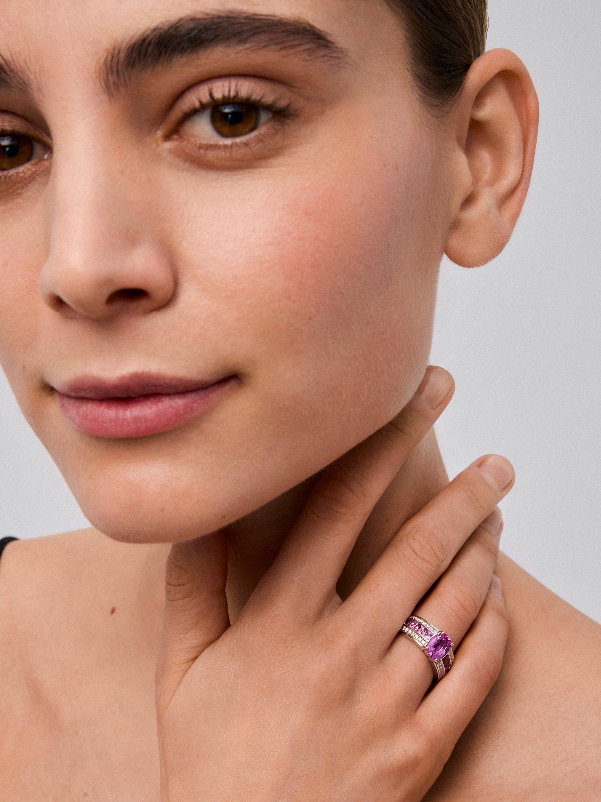 Anillo de oro blanco de 18K con zafiro rosa en talla oval de 1,7 cts, 12 zafiros rosas en talla princesa con un total de 2 cts y diamantes en talla brillante con un total de 0,3 cts