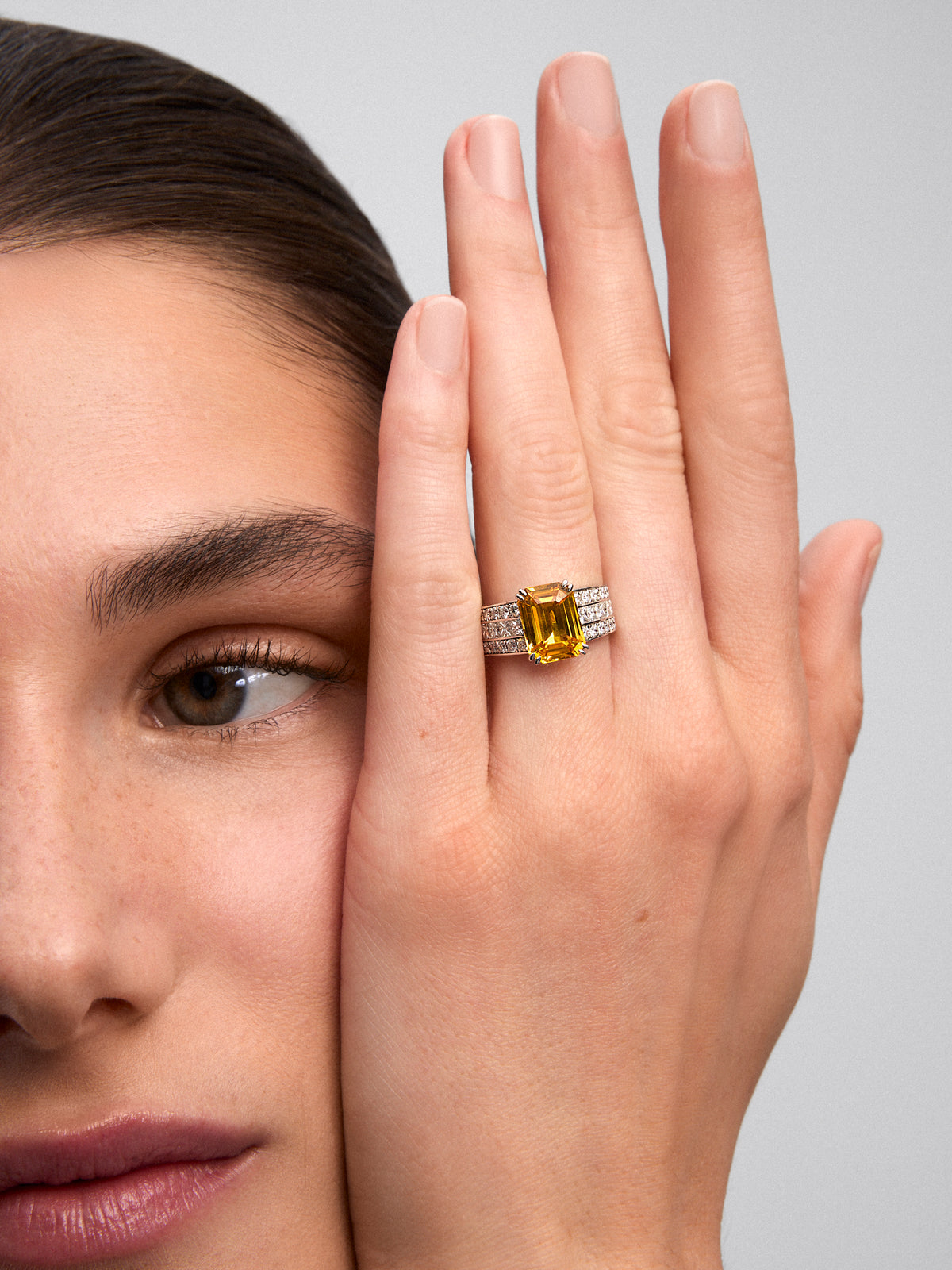 Anillo de oro blanco con zafiro amarillo central y brazo de diamantes