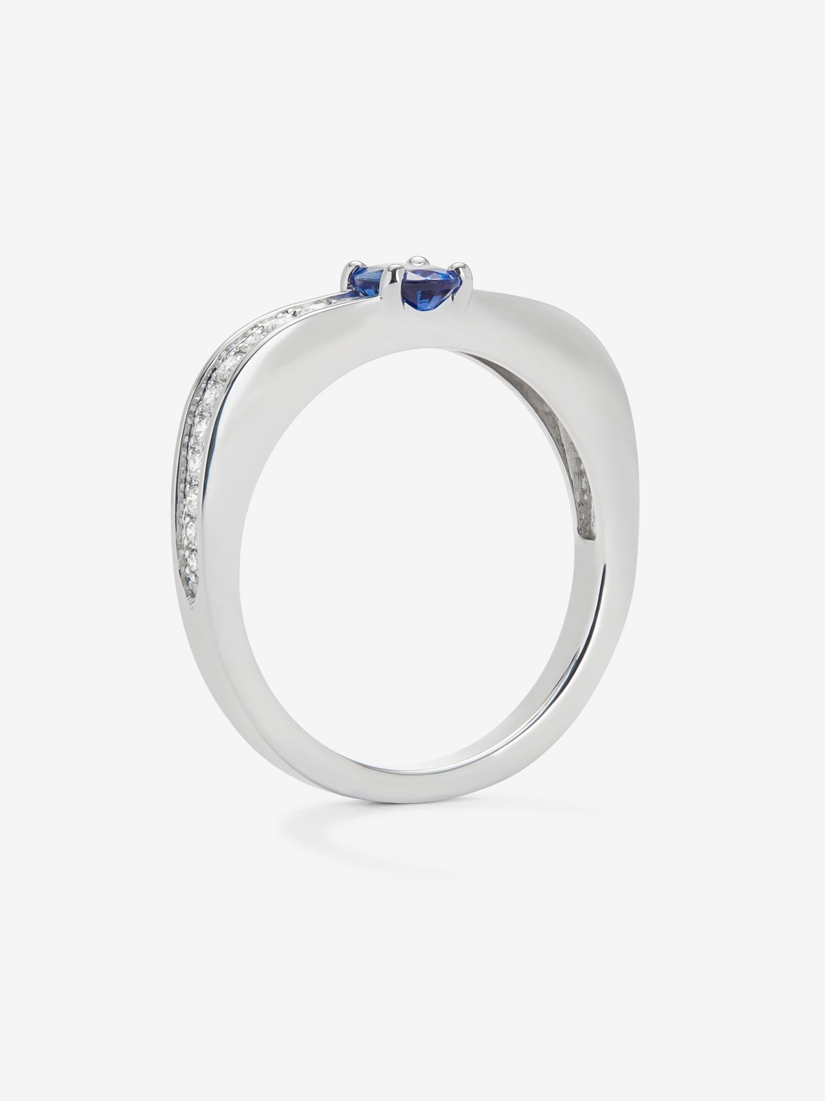 Anillo de oro blanco de 18K con zafiro azul en talla oval de 0,47 cts y 22 diamantes en talla brillante con un total de 0,16 cts