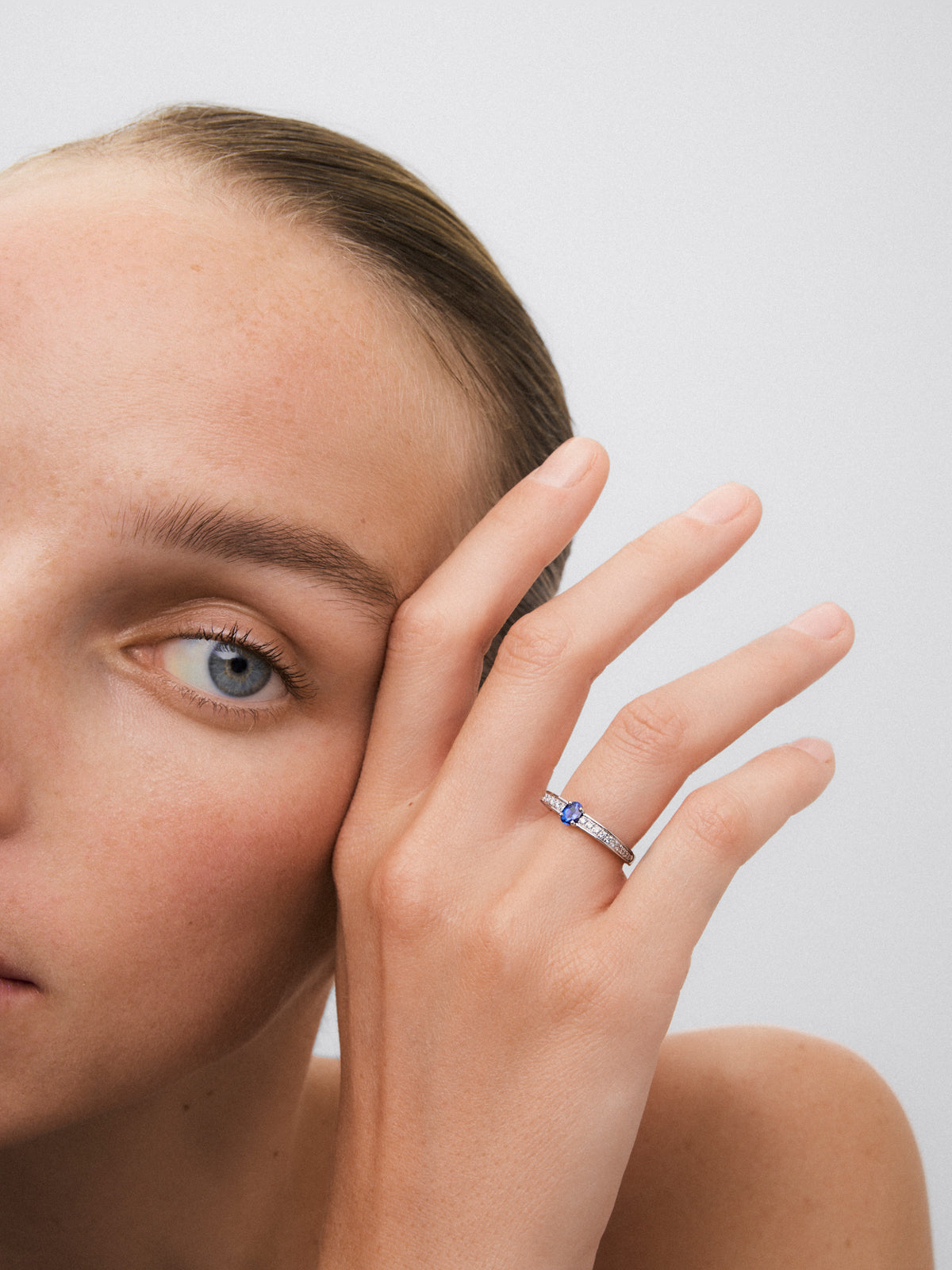 Anillo de oro blanco de 18K con zafiro azul en talla oval de 0,40 cts y 22 diamantes en talla brillante con un total de 0,19 cts
