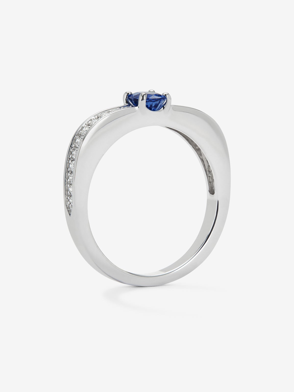 Anillo de oro blanco de 18K con zafiro azul en talla oval de 0,44 cts y 22 diamantes en talla brillante con un total de 0,16 cts