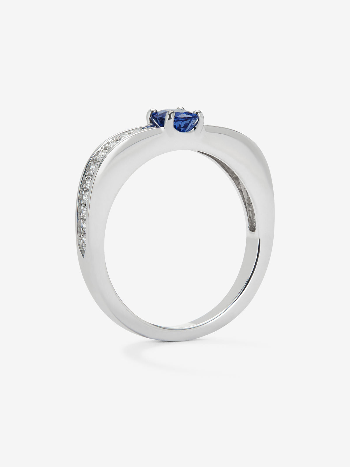 Anillo de oro blanco de 18K con zafiro azul en talla oval de 0,40 cts y 22 diamantes en talla brillante con un total de 0,19 cts