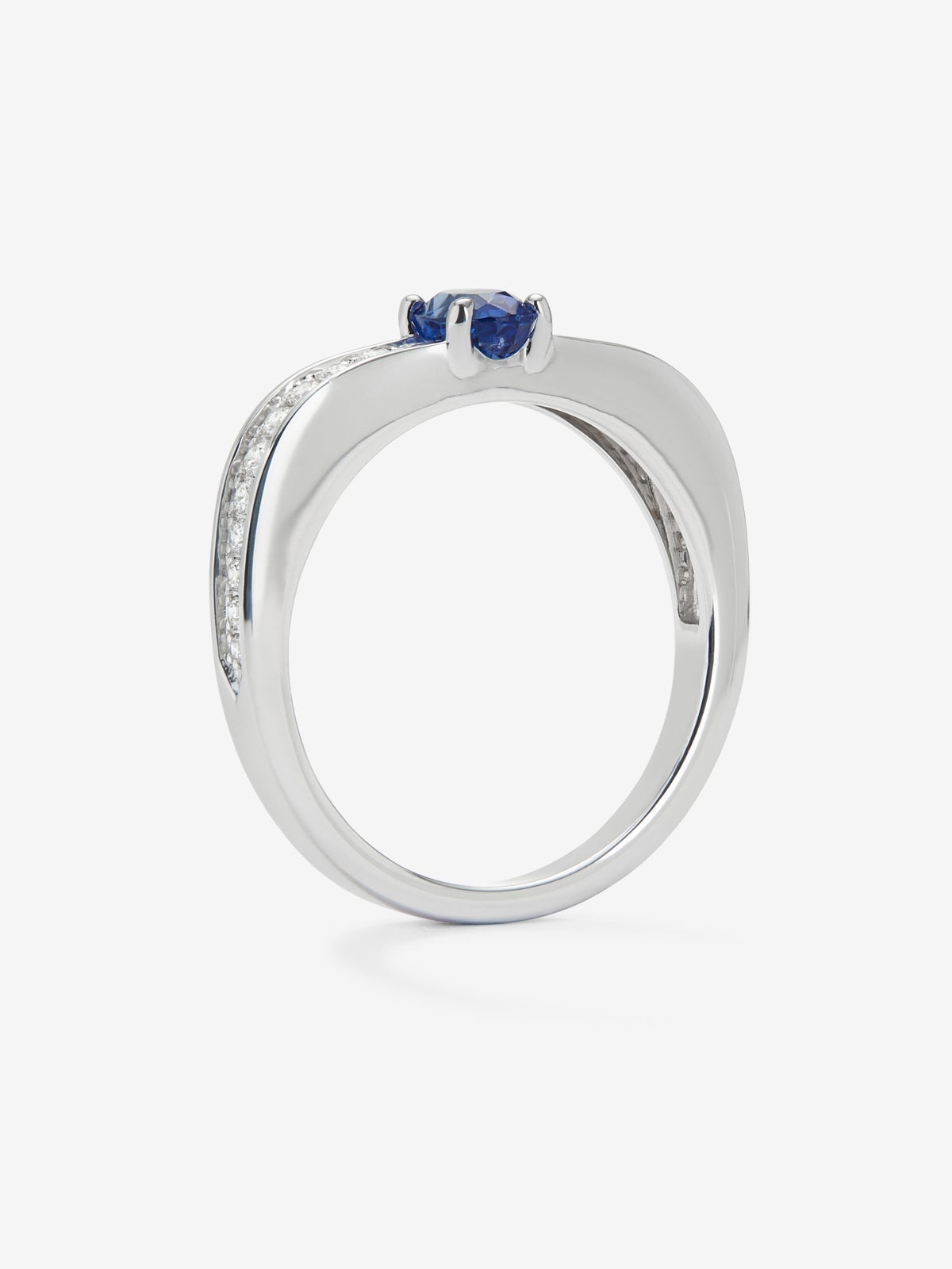 Anillo de oro blanco de 18K con zafiro azul en talla oval de 0,44 cts y 22 diamantes en talla brillante con un total de 0,15 cts