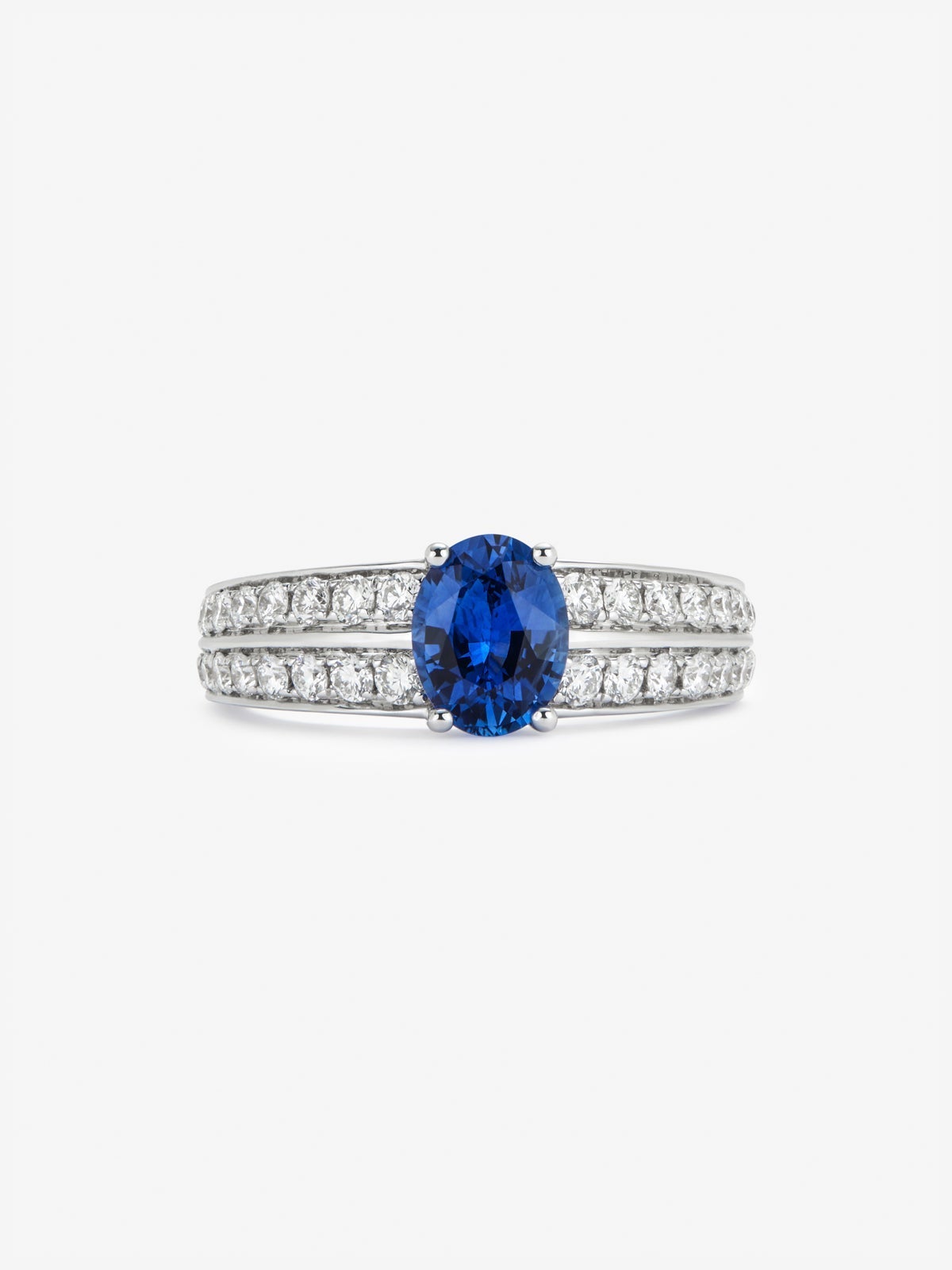 Anillo de oro blanco de 18K con zafiro azul vivid en talla oval de 1,292 cts y 32 diamantes en talla brillante con un total de 0,6 cts