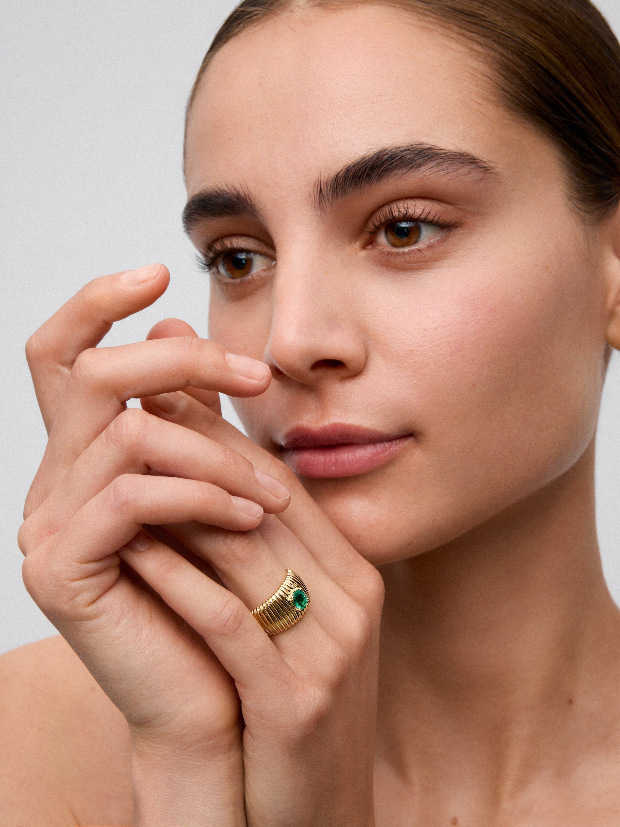 Anillo gallonado de oro amarillo de 18K con esmeralda en talla oval