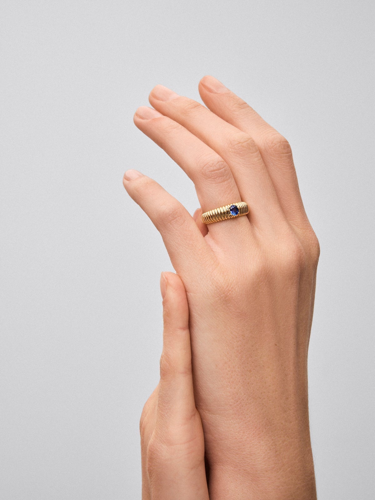 Anillo gallonado de oro amarillo de 18K con zafiro en talla oval