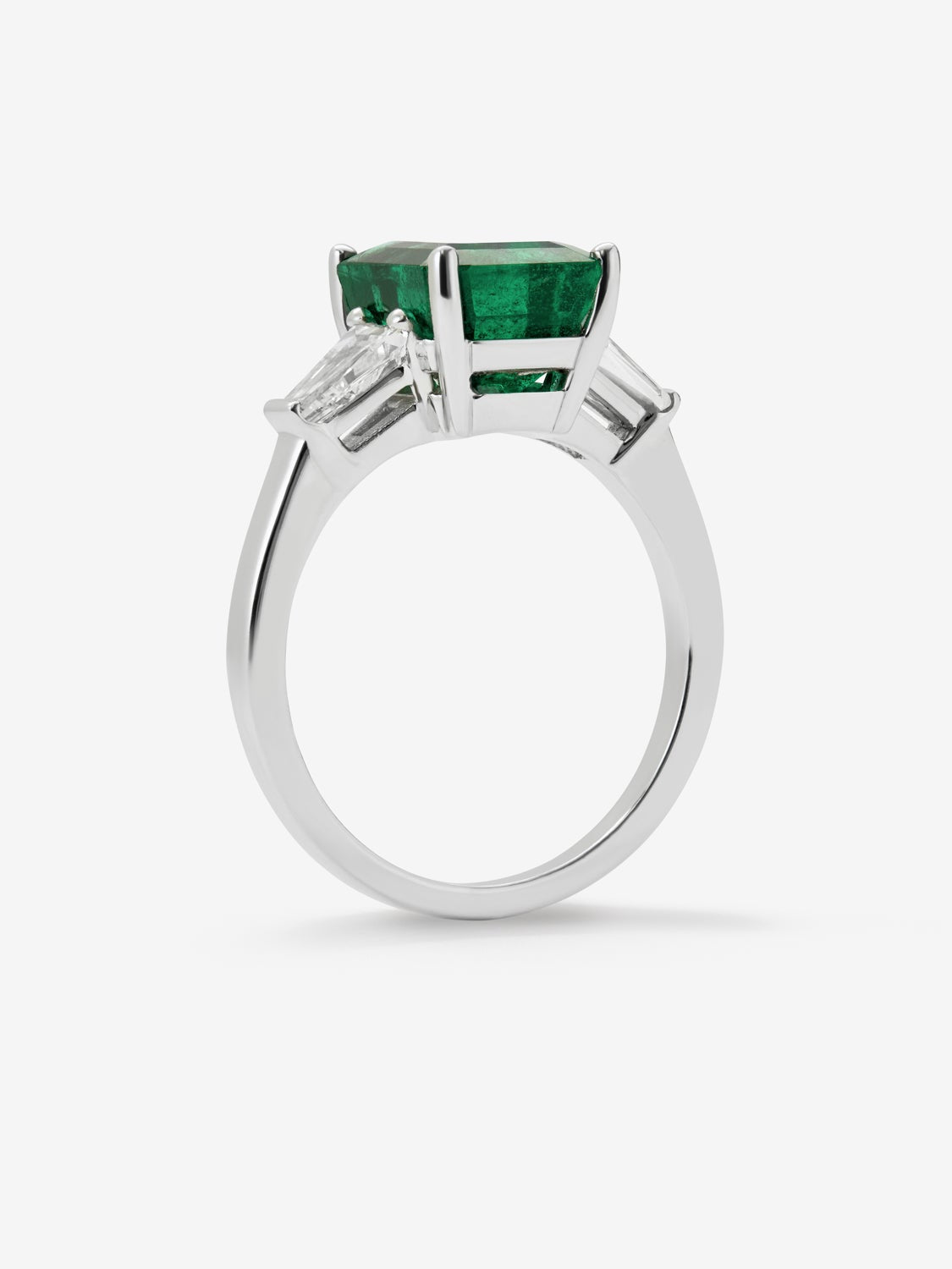 Anillo tresillo de oro blanco de 18K con esmeralda verde en talla octogonal de 3,6 cts y 2 diamantes en talla trapecio con un total de 0,68 cts
