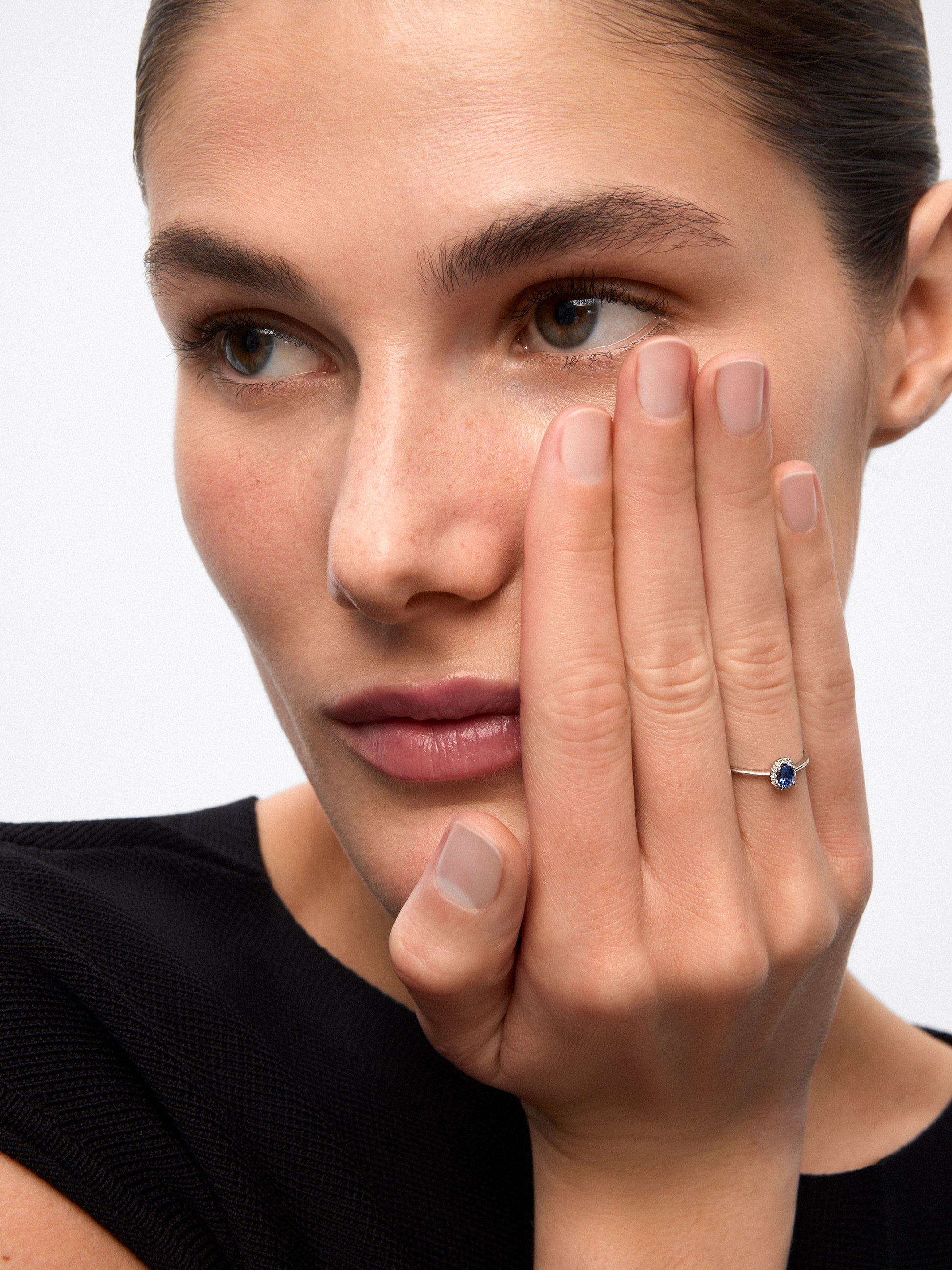 Anillo de oro blanco de 18K con zafiro azul en talla oval de 0,25 cts y 12 diamantes en talla brillante con un total de 0,06 cts