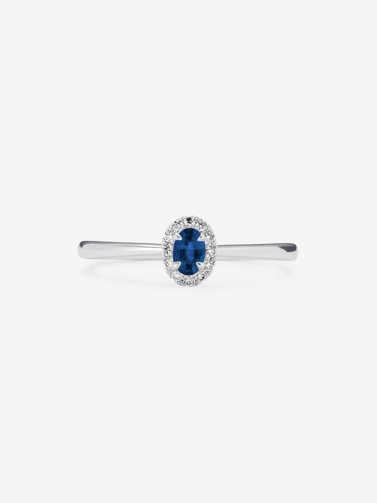 Anillo de oro blanco de 18K con zafiro azul en talla oval de 0,25 cts y 12 diamantes en talla brillante con un total de 0,06 cts