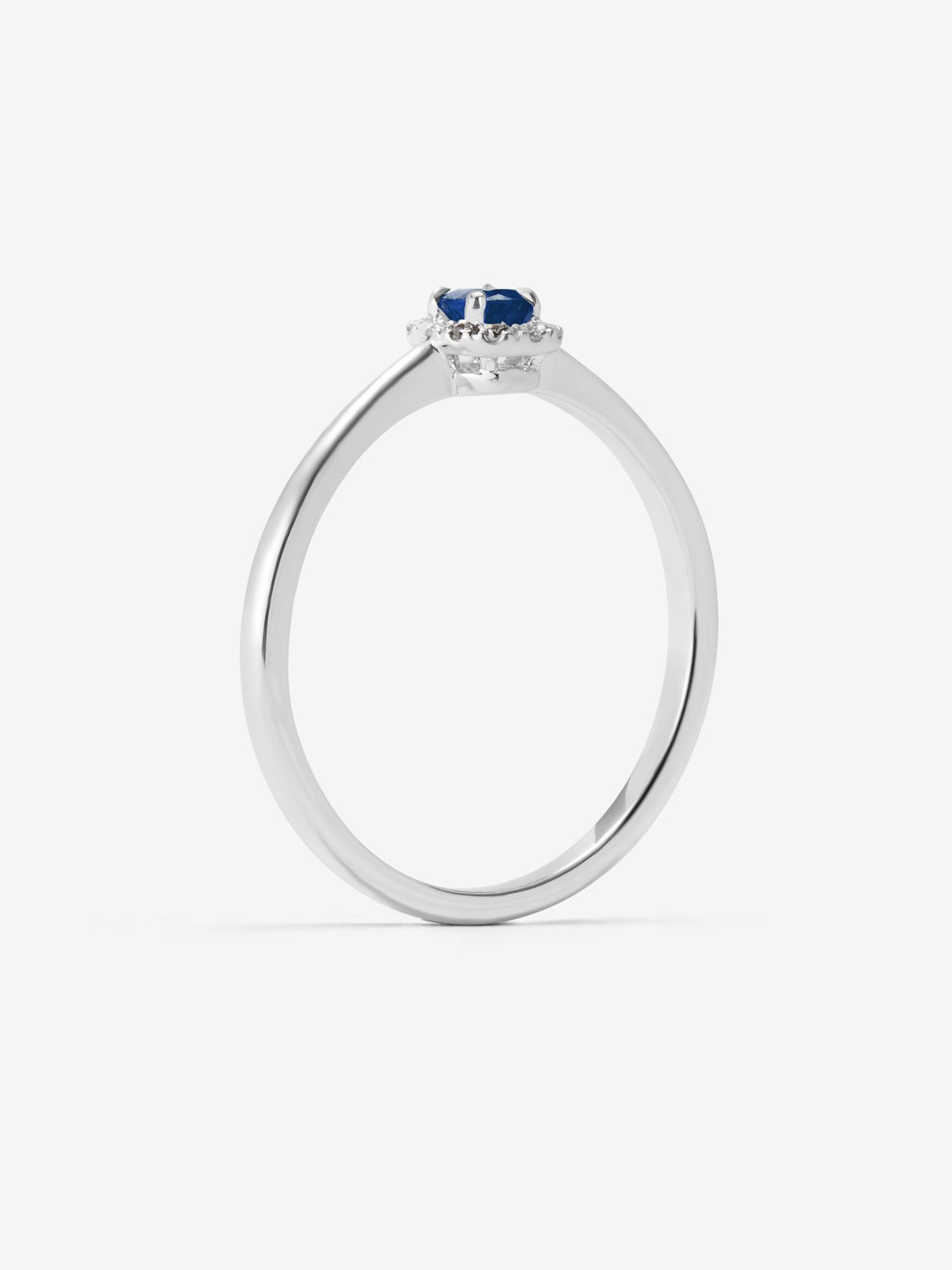 Anillo de oro blanco de 18K con zafiro azul en talla oval de 0,25 cts y 12 diamantes en talla brillante con un total de 0,06 cts
