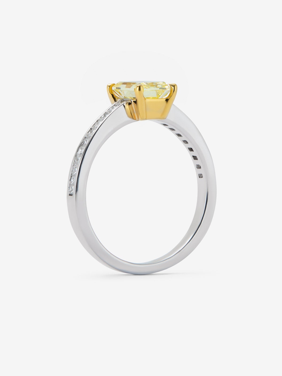 Anillo solitario de oro blanco y amarillo de 18K con diamante central Fancy Yellow en talla radiant de 1,19 cts y  18 diamantes en talla brillante con un total de 0,236 cts
