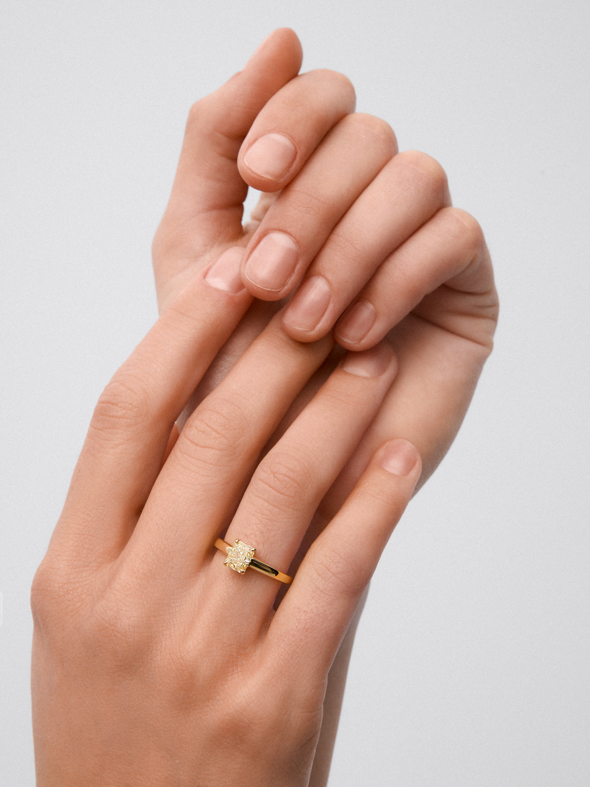Anillo solitario de oro amarillo de 18K con diamante central Fancy Yellow en talla radiant de 0,70 cts 