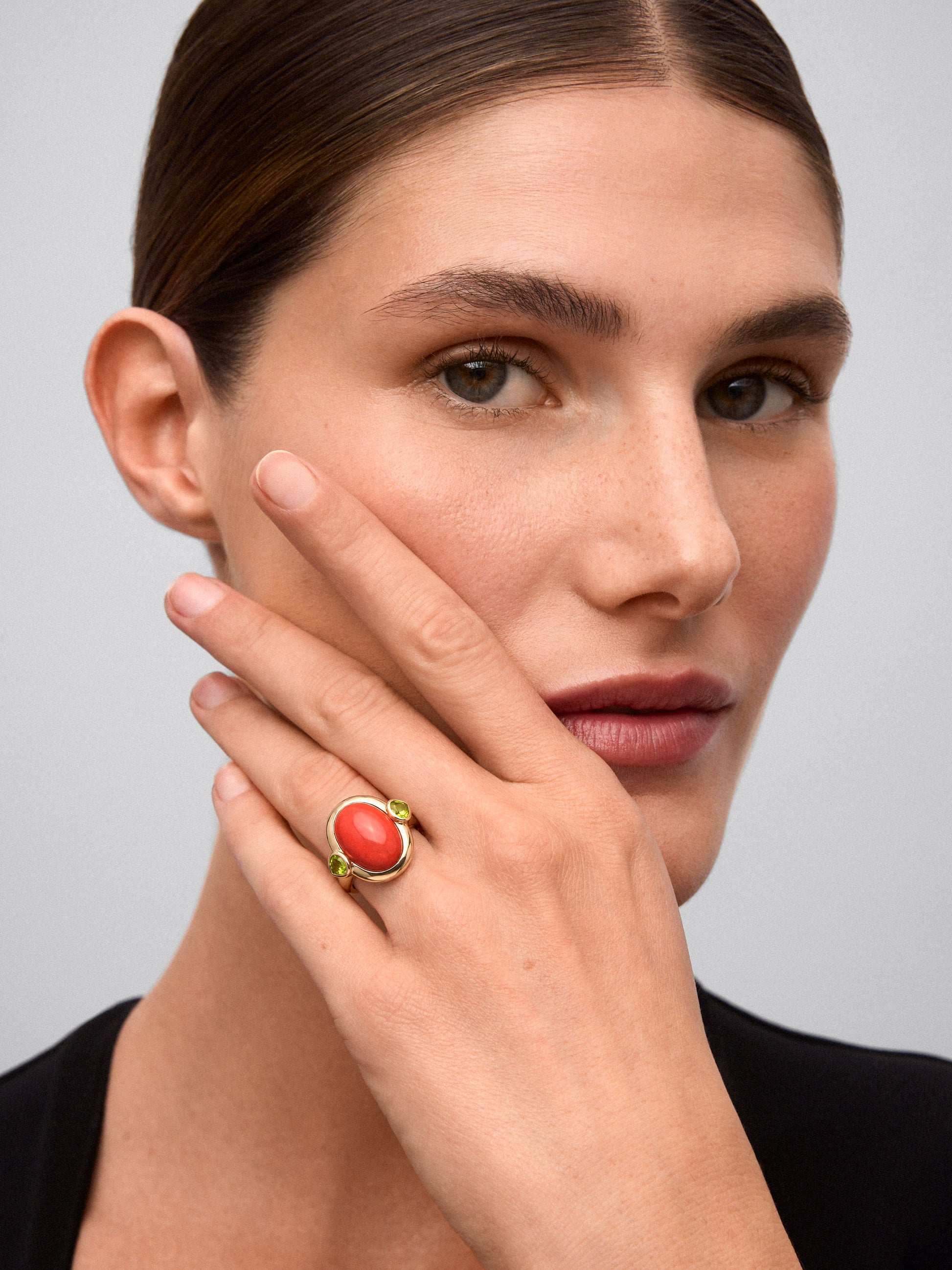 Anillo de oro amarillo de 18K con coral en talla oval y 2 peridotos verdes en talla pera