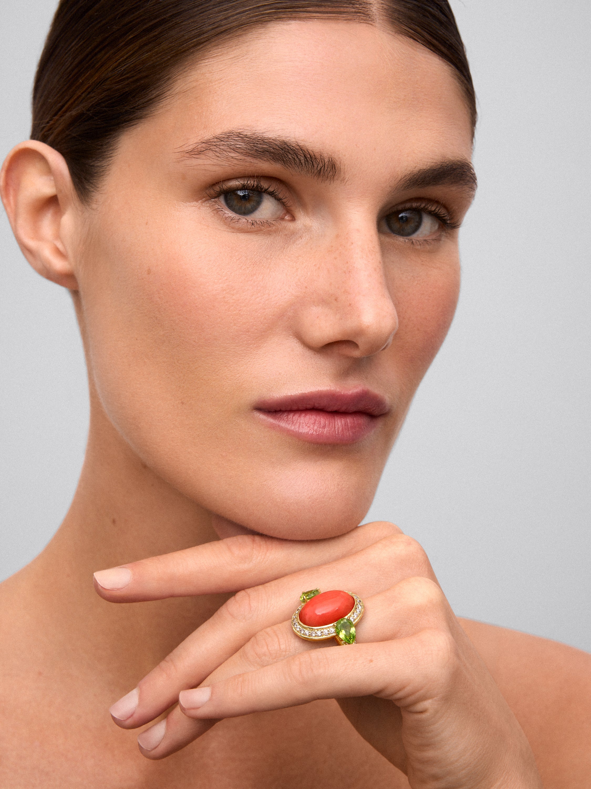 Anillo de oro amarillo de 18K con coral en talla oval, 2 peridotos verdes en talla pera y 30 diamantes en talla brillante con un total de 0,3 cts