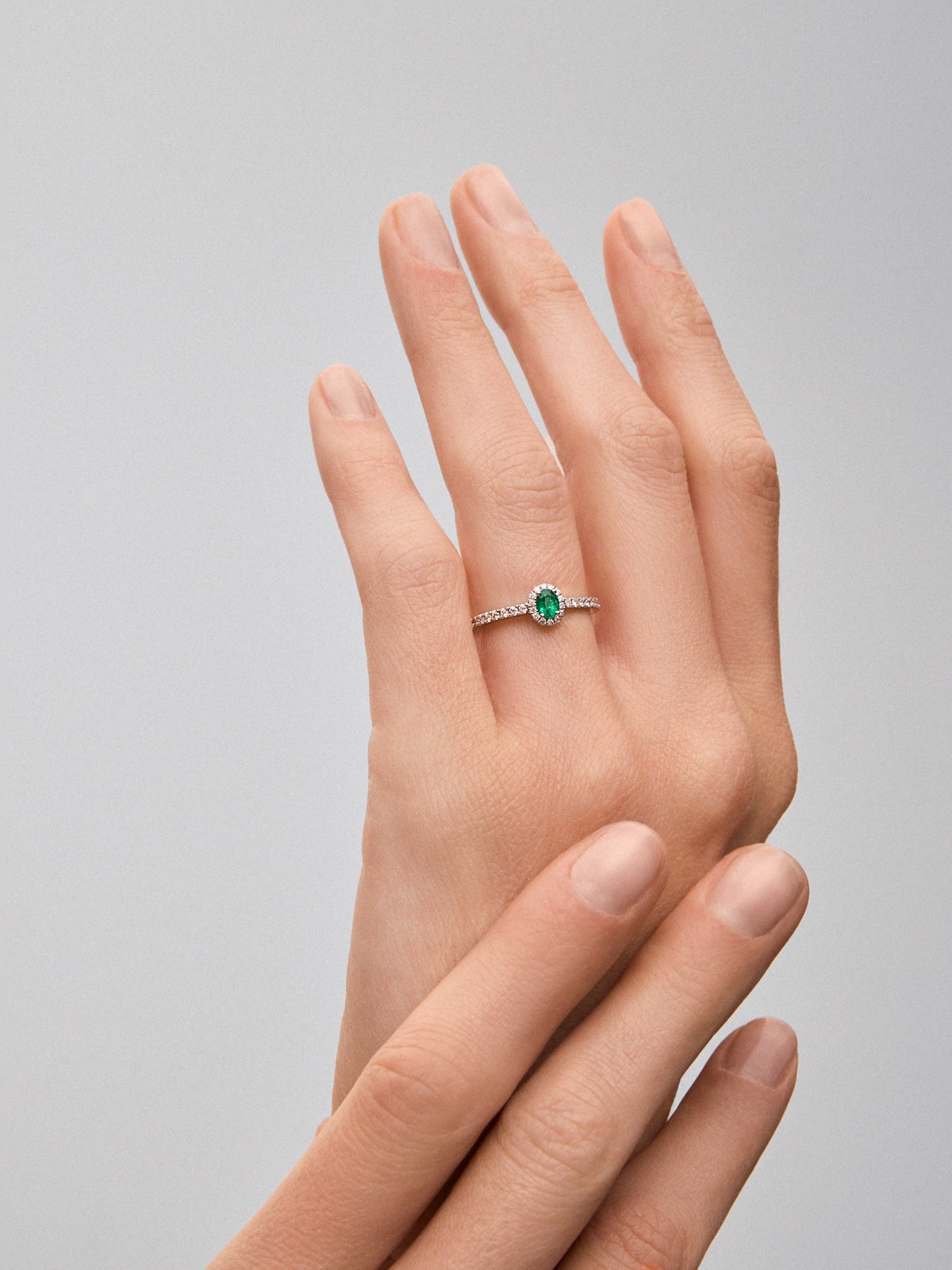 Anillo de oro blanco de 18K con esmeralda en talla oval de 0,39 cts y 32 diamantes en talla brillante con un total de 0,3 cts