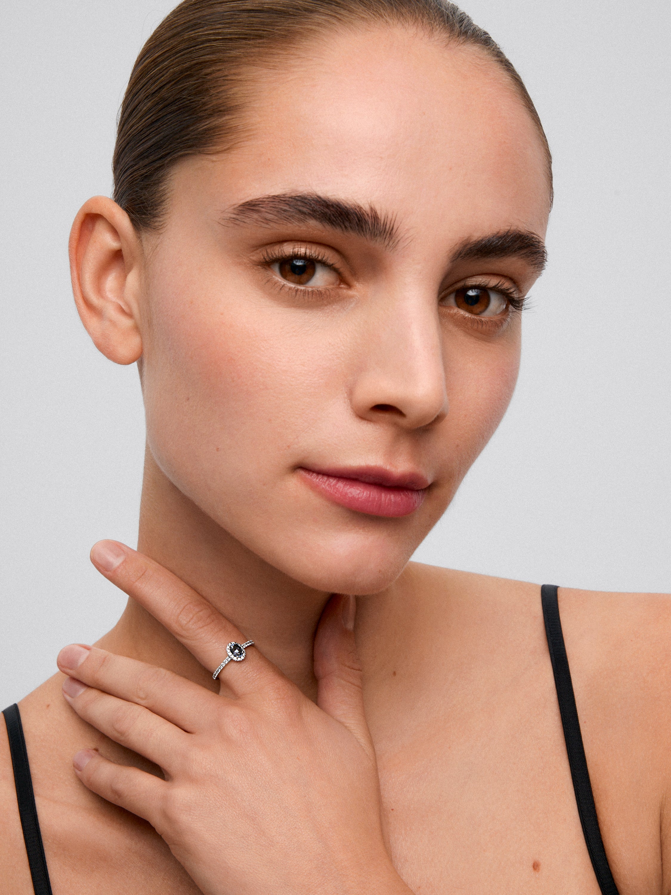 Anillo de oro blanco de 18K con zafiro azul en talla oval de 0,91 cts y orla de diamantes en talla brillante con un total de 0,37 cts
