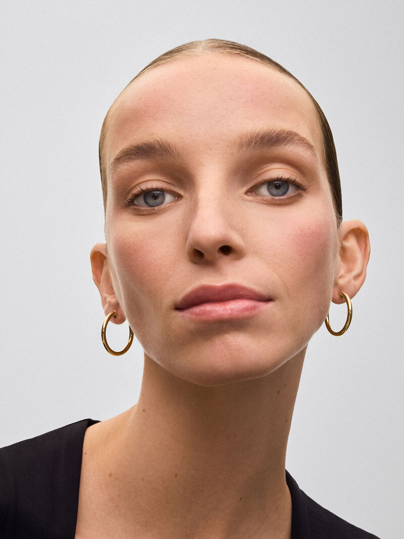 Medium smooth hoop earrings in 18K yellow gold. image number 1