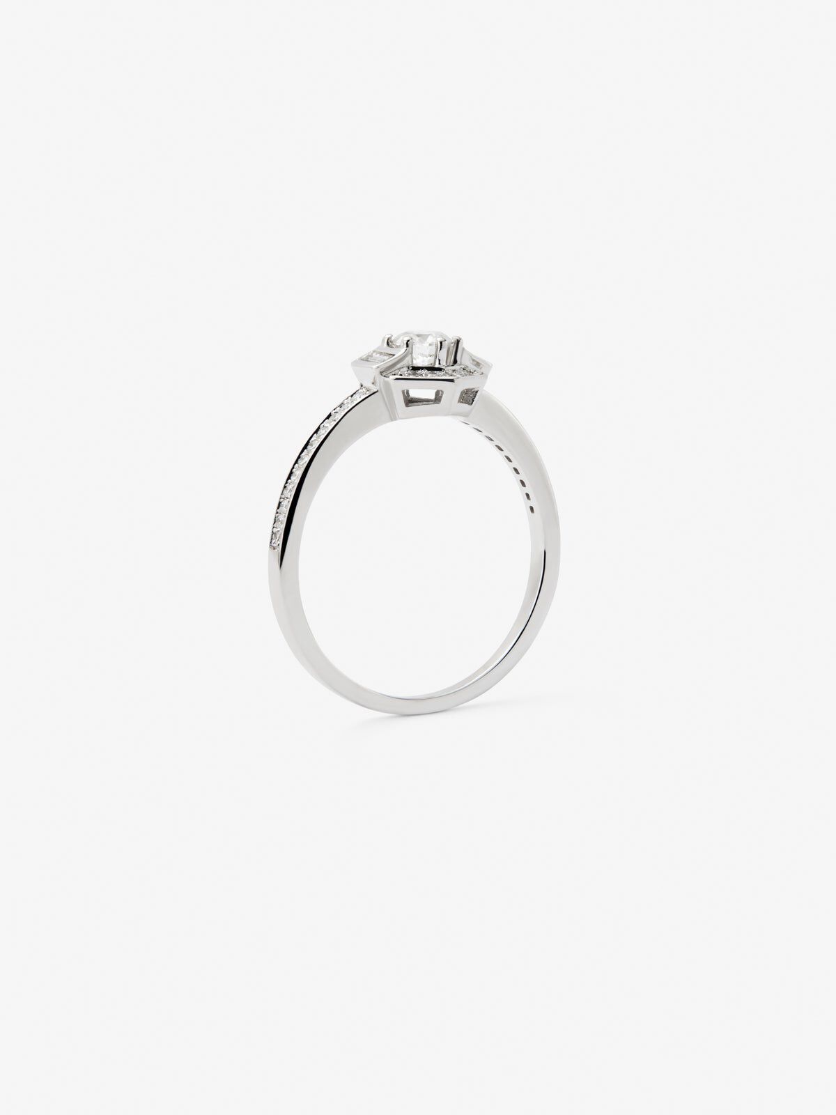 Anillo de oro blanco de 18K con un diamante central en talla brillante de 0 2 cts 2 en talla baguette con un total de 0 05 cts y 38 en talla brillante con