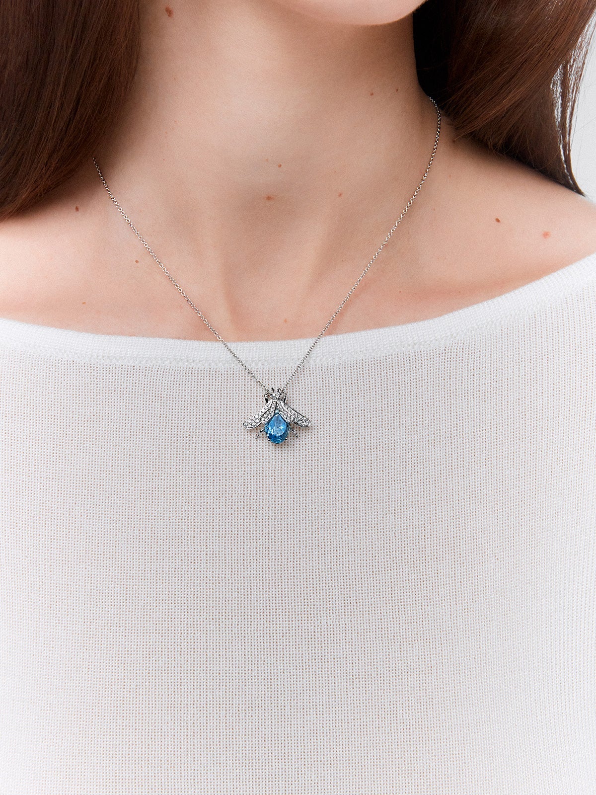 Colgante mosca de oro blanco de 18kt con diamantes y piedras azules