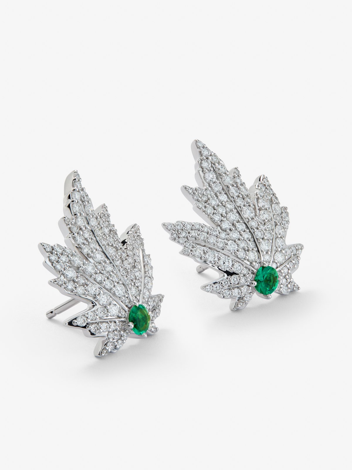 Pendientes de oro blanco de 18K con 2 esmeraldas centrales con un total de 0,34 cts, pavé de diamantes y forma de hoja de arce