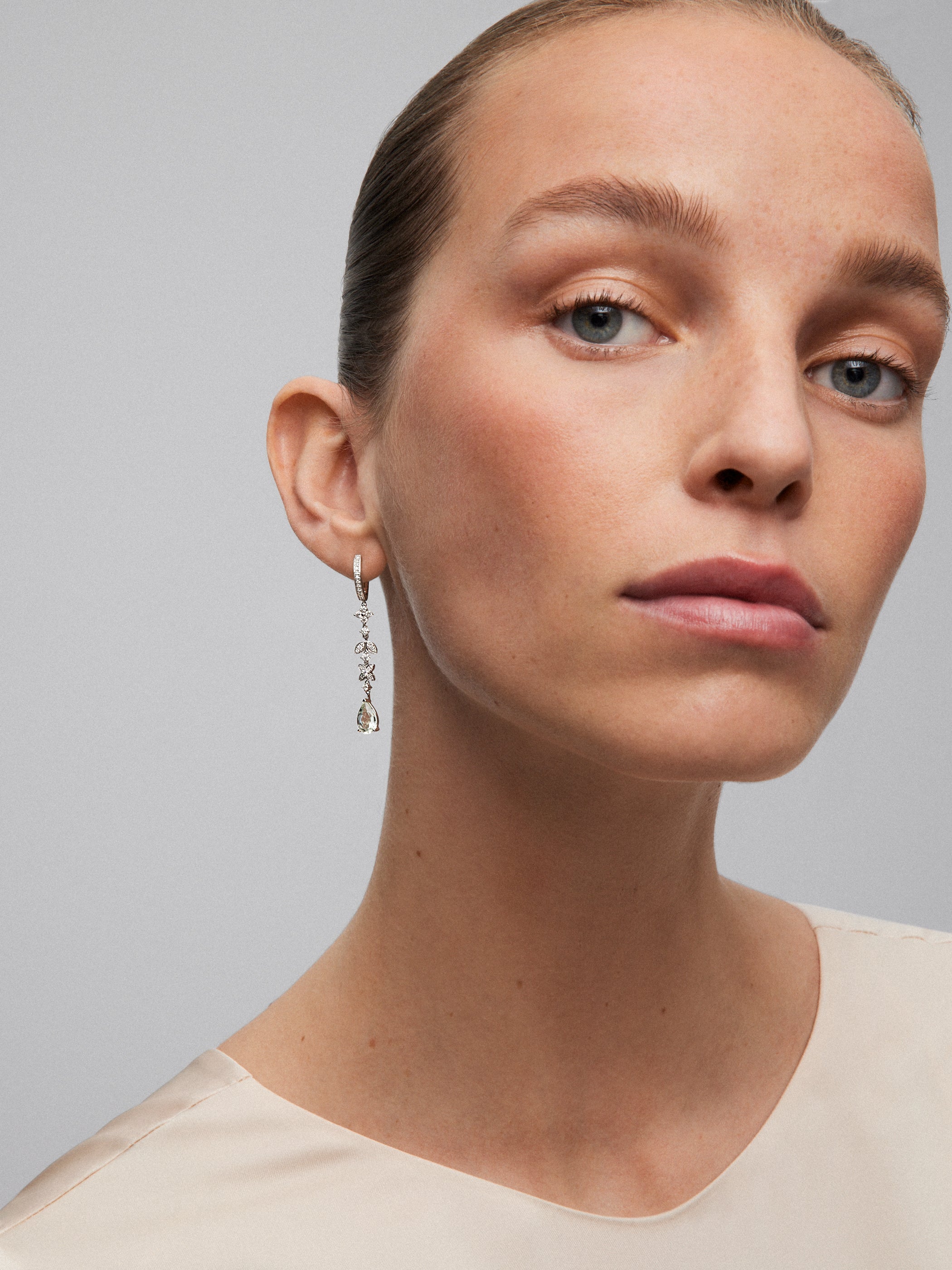 18K white gold earrings with 64 brilliant-cut diamonds with a total of 0.64 cts and 2 pear-cut green amethysts