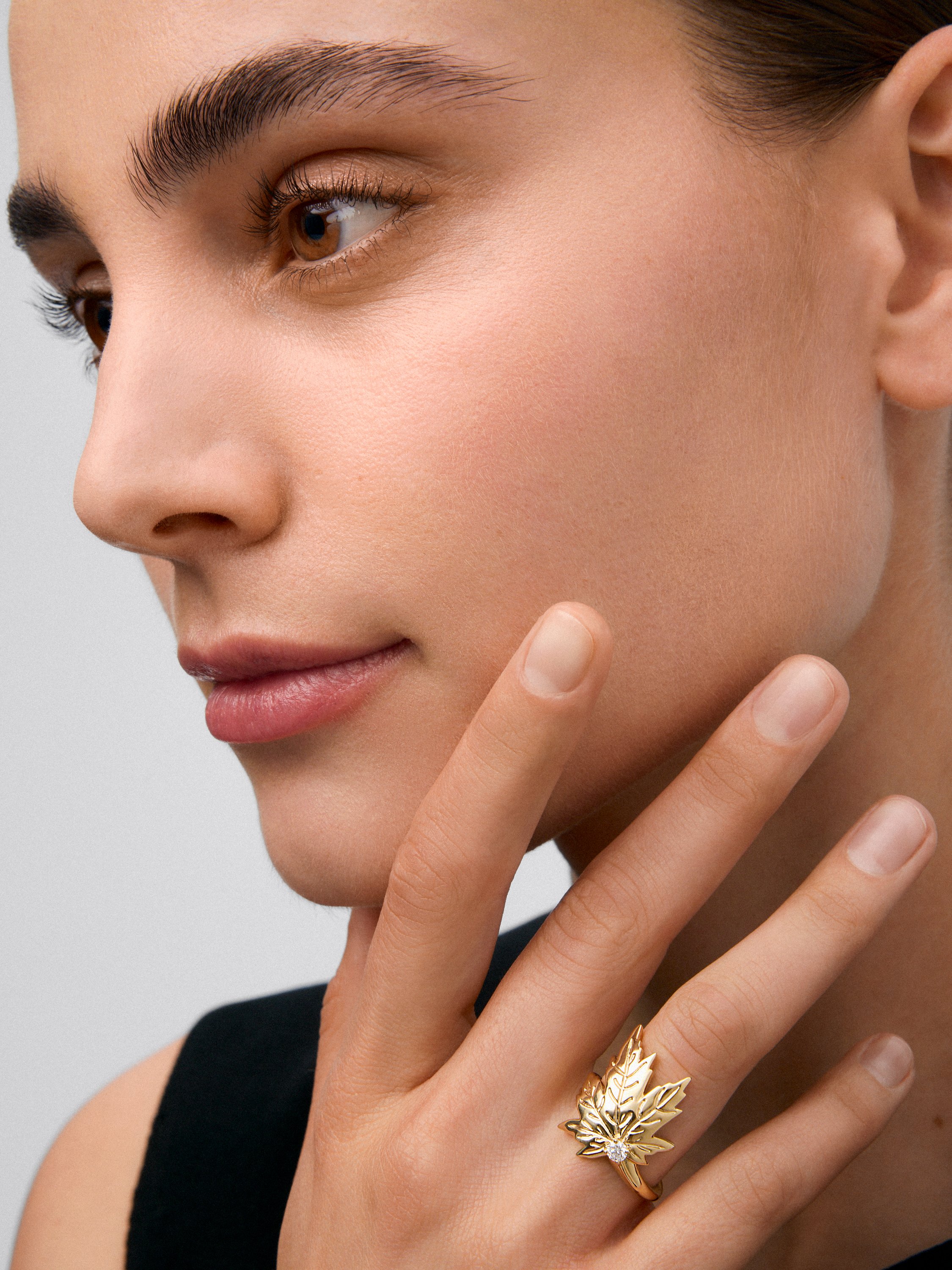 Anillo de oro amarillo de 18K con diamante central en talla brillante de 0,12 cts y forma de hoja de arce 