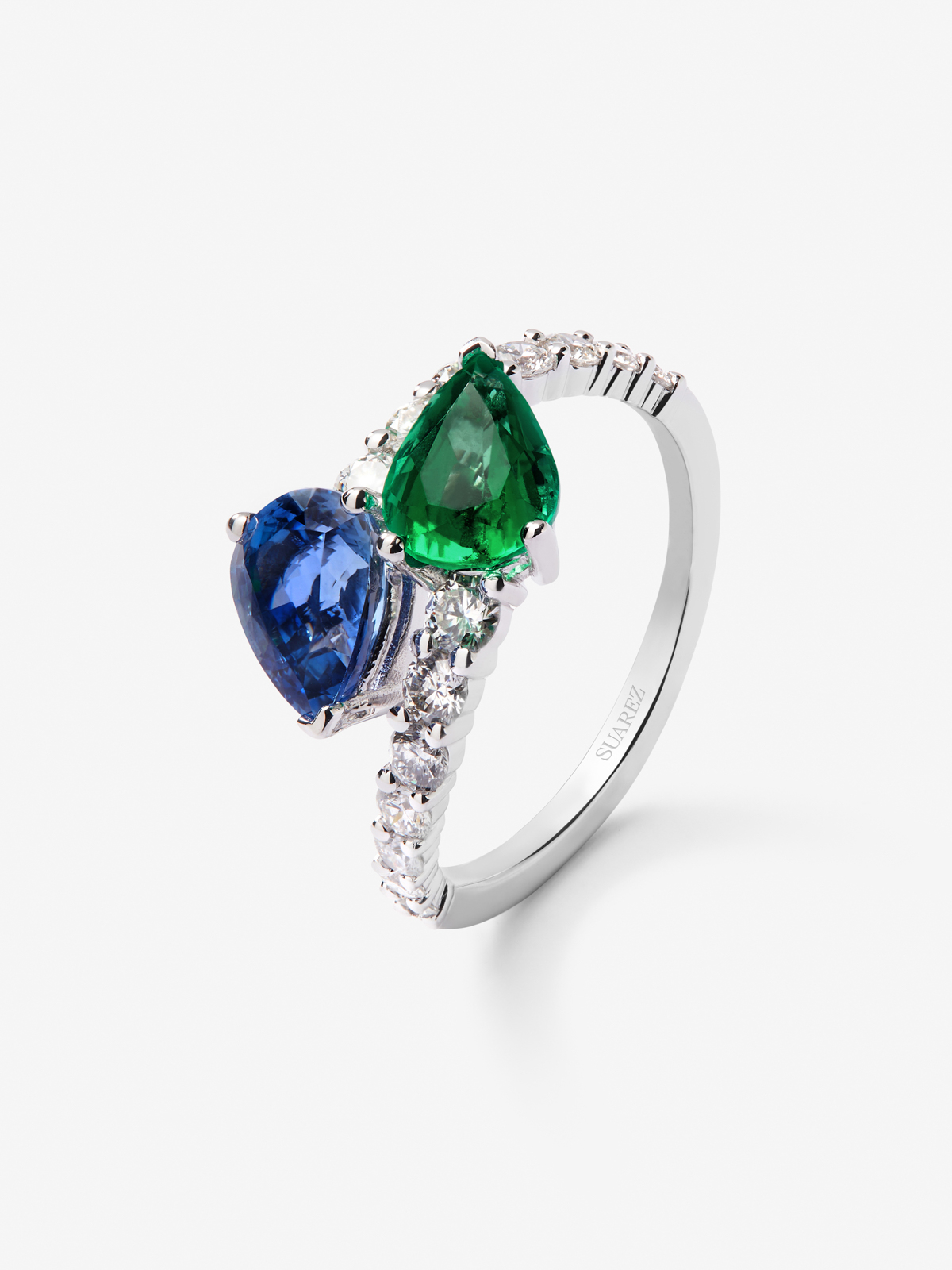 Anillo tú y yo de oro blanco de 18K con zafiro azul intenso en talla pera de 1,49 cts, esmeralda verde en talla pera de 1,04 cts y diamantes blancos en talla brillante de 0,64 cts