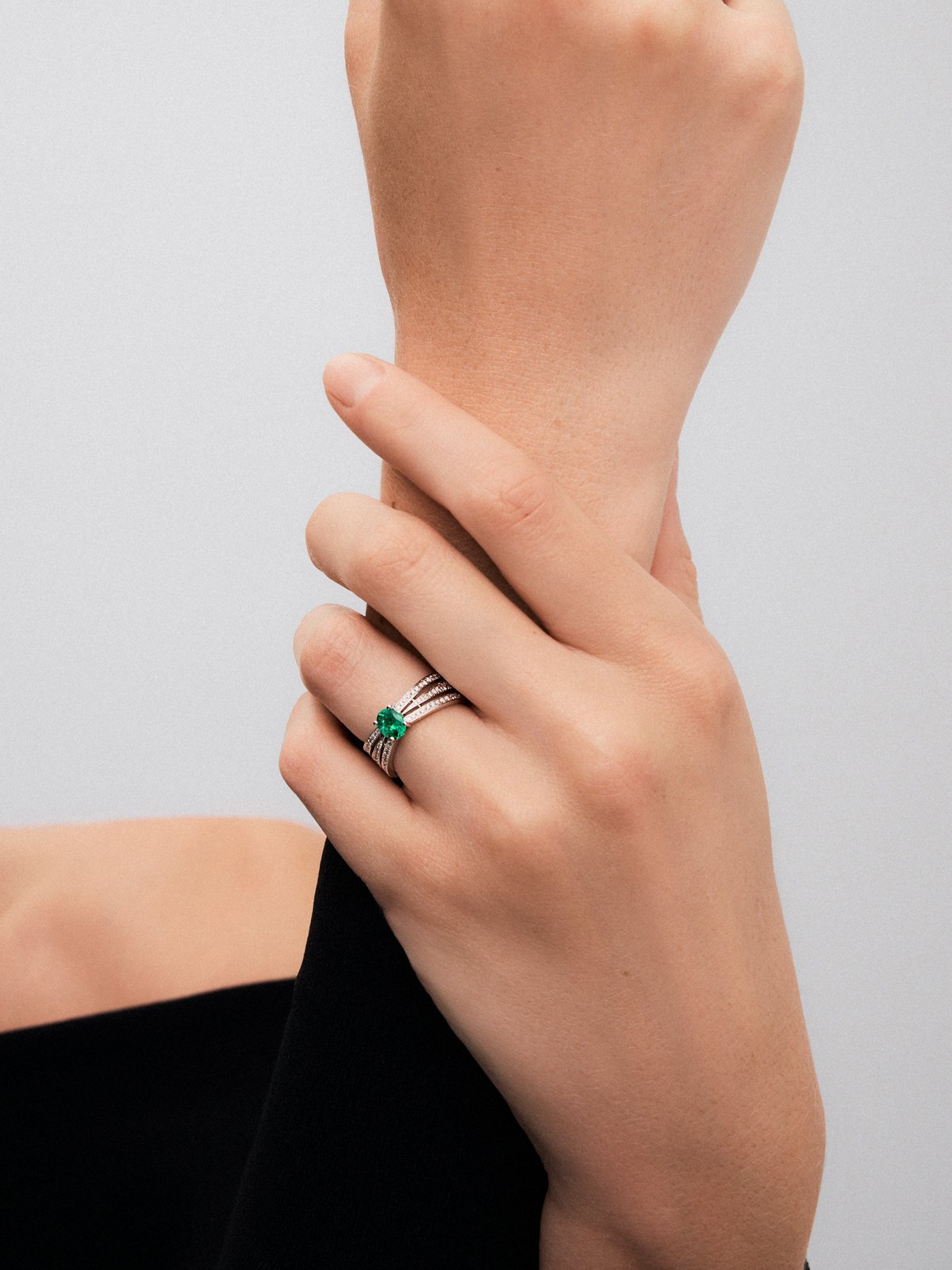 18K white gold multi-arm ring with oval-cut emerald ​​of 0.63 cts and brilliant-cut diamonds with a total of 0.43 cts