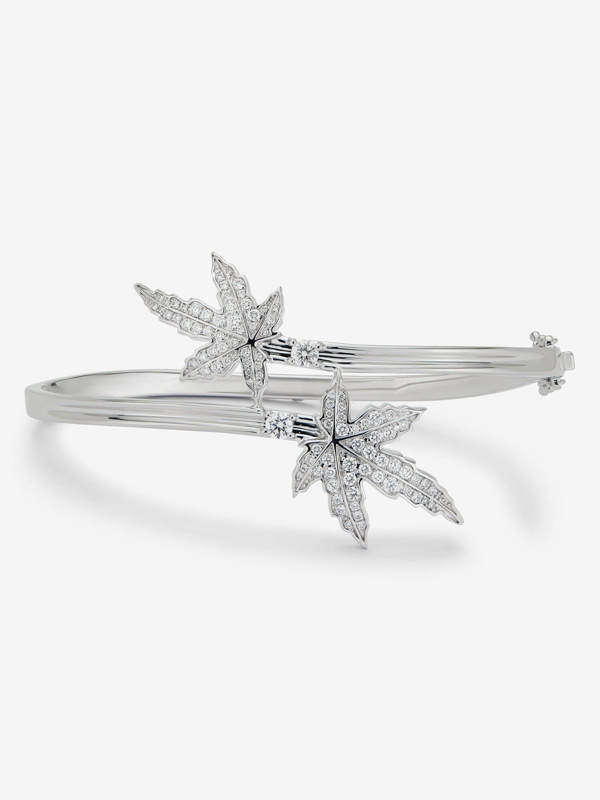 18K white gold bracelet with two central emeralds totaling 0.24 cts, diamond pavé, and a maple leaf design.