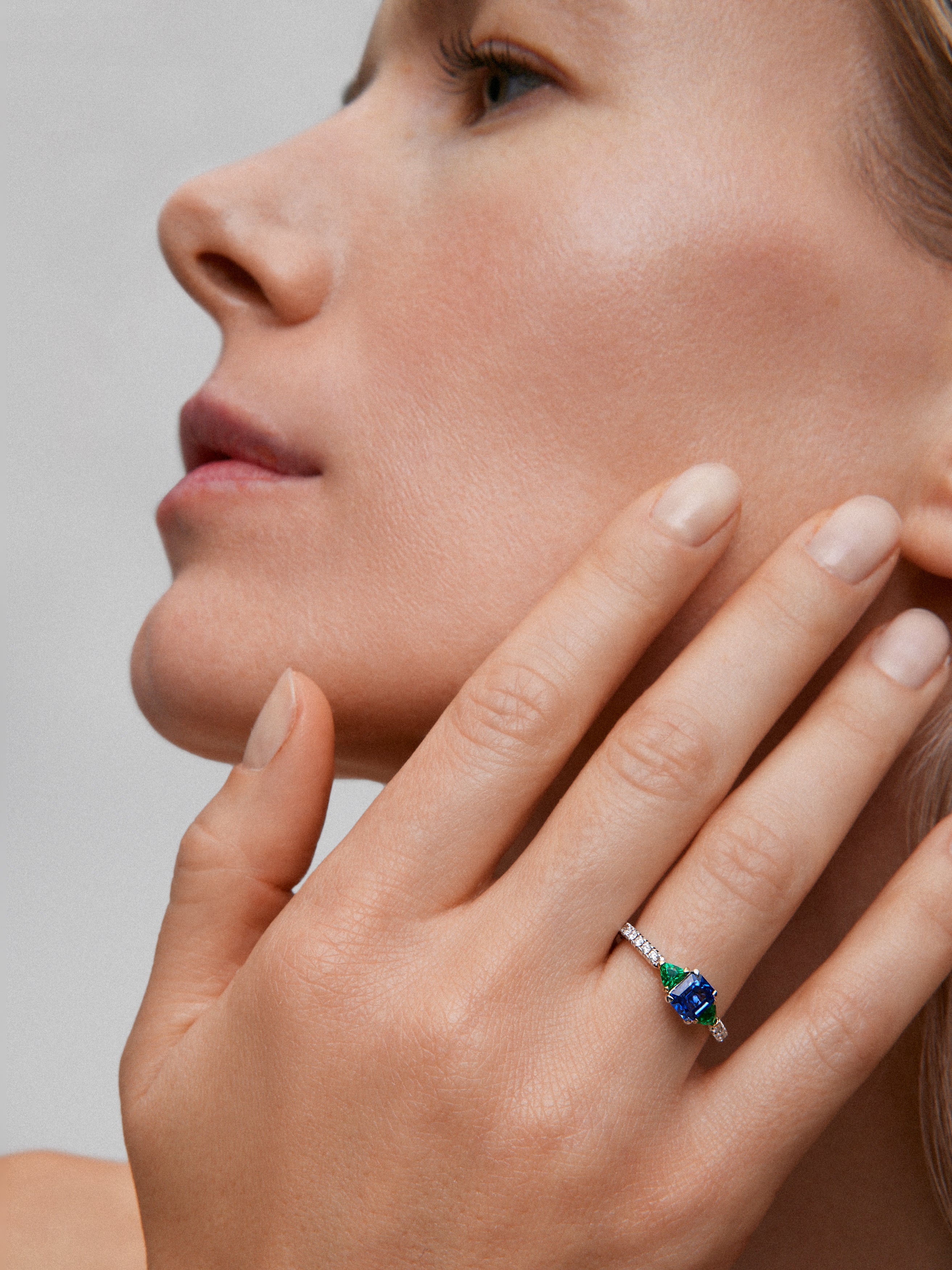 Anillo de oro blanco de 18K con zafiro azul en talla octogonal de 0,94 cts, esmeraldas verdes en talla trillon de 0,22 cts y diamantes blancos en talla brillante de 0,028 cts