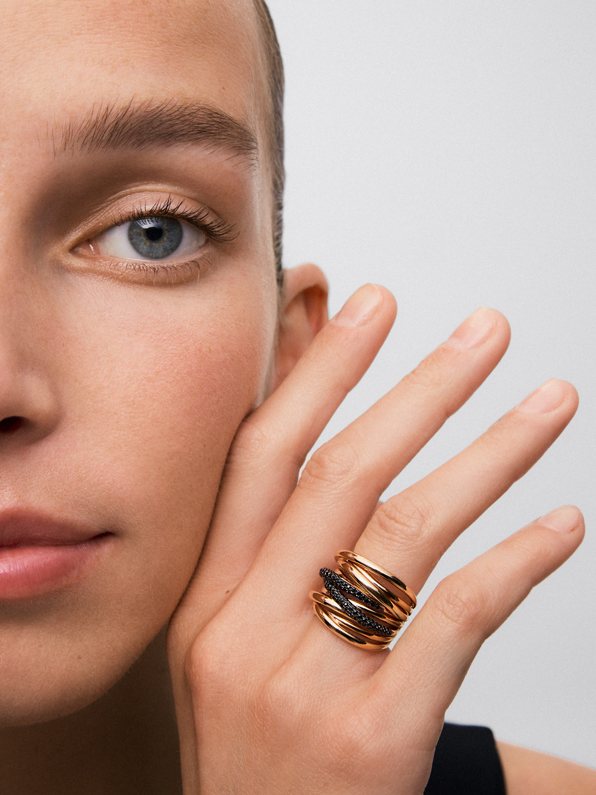 Anillo entrelazado multibrazo de oro rosa de 18kt con piedras espinelas negras