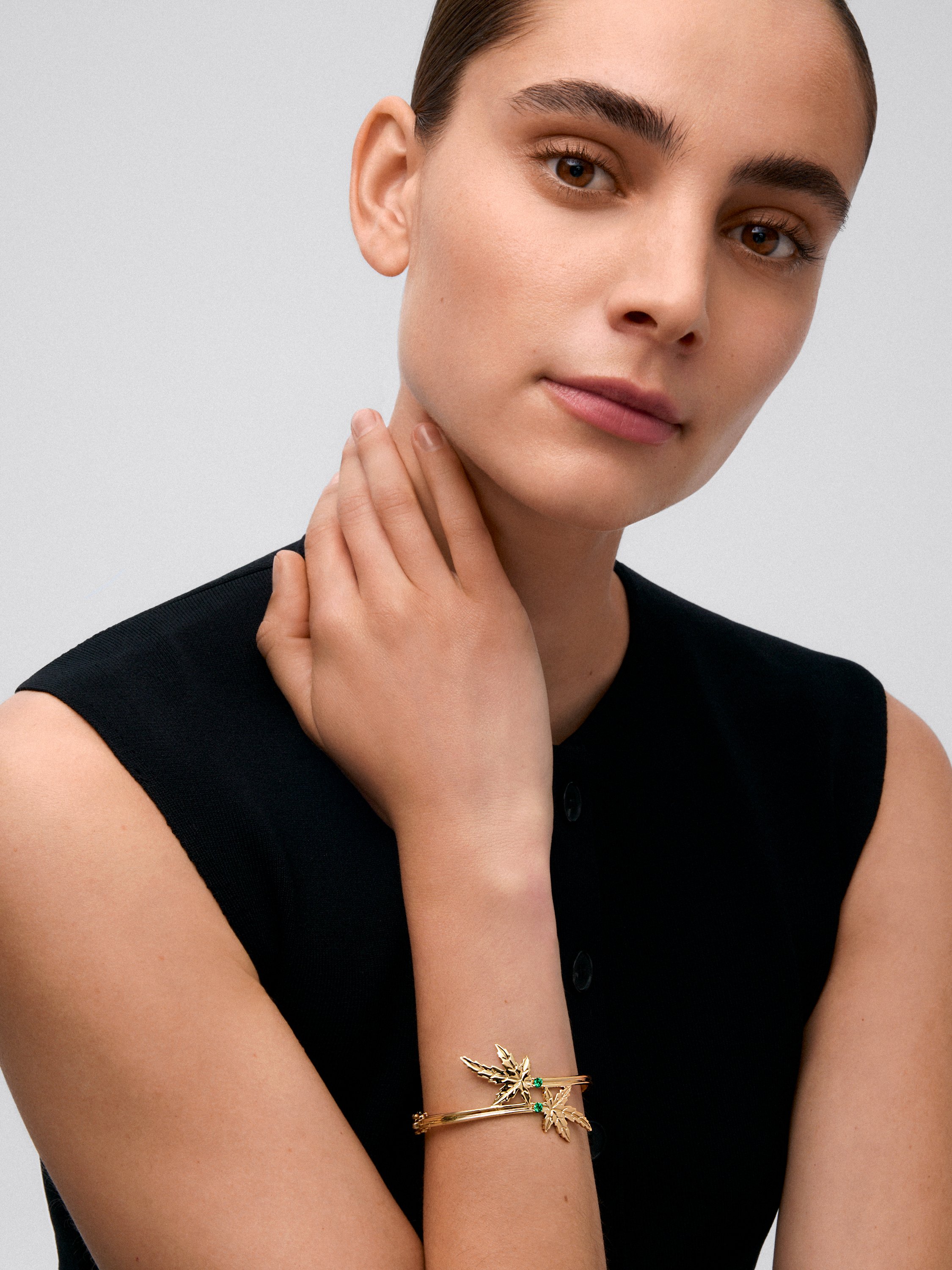Pulsera de oro amarillo de 18K con 2 esmeraldas en talla brillante con un total de 0,23 cts y forma de hoja de arce