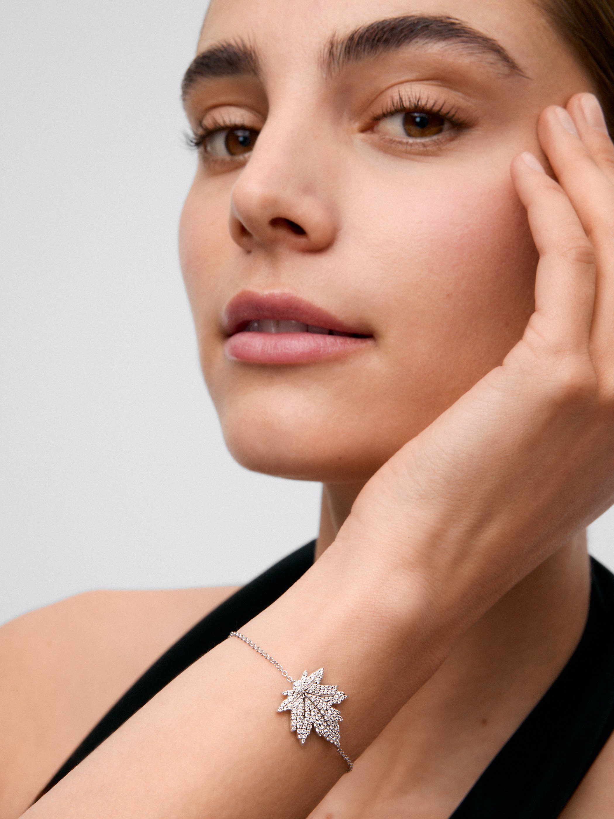18K white gold bracelet with a 0.14 ct central brilliant-cut diamond, diamond pavé, and a maple leaf design