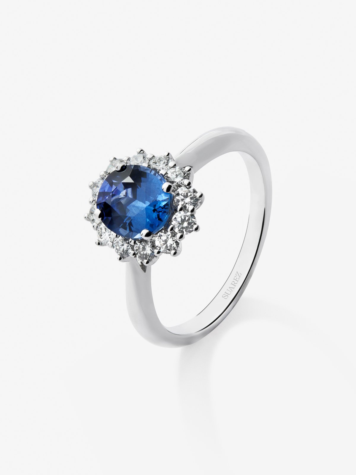 Anillo de oro blanco de 18K con zafiro azul en talla oval de 1,5 cts y 12 diamantes en talla brillante con un total de 0,53 cts
