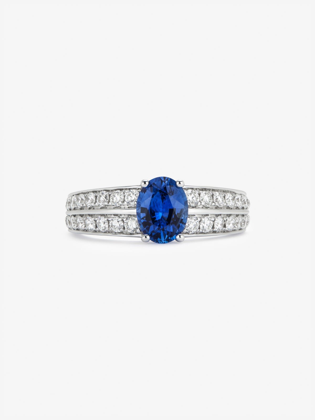 Anillo de oro blanco de 18K con zafiro azul vivid en talla oval de 1,292 cts y 32 diamantes en talla brillante con un total de 0,6 cts