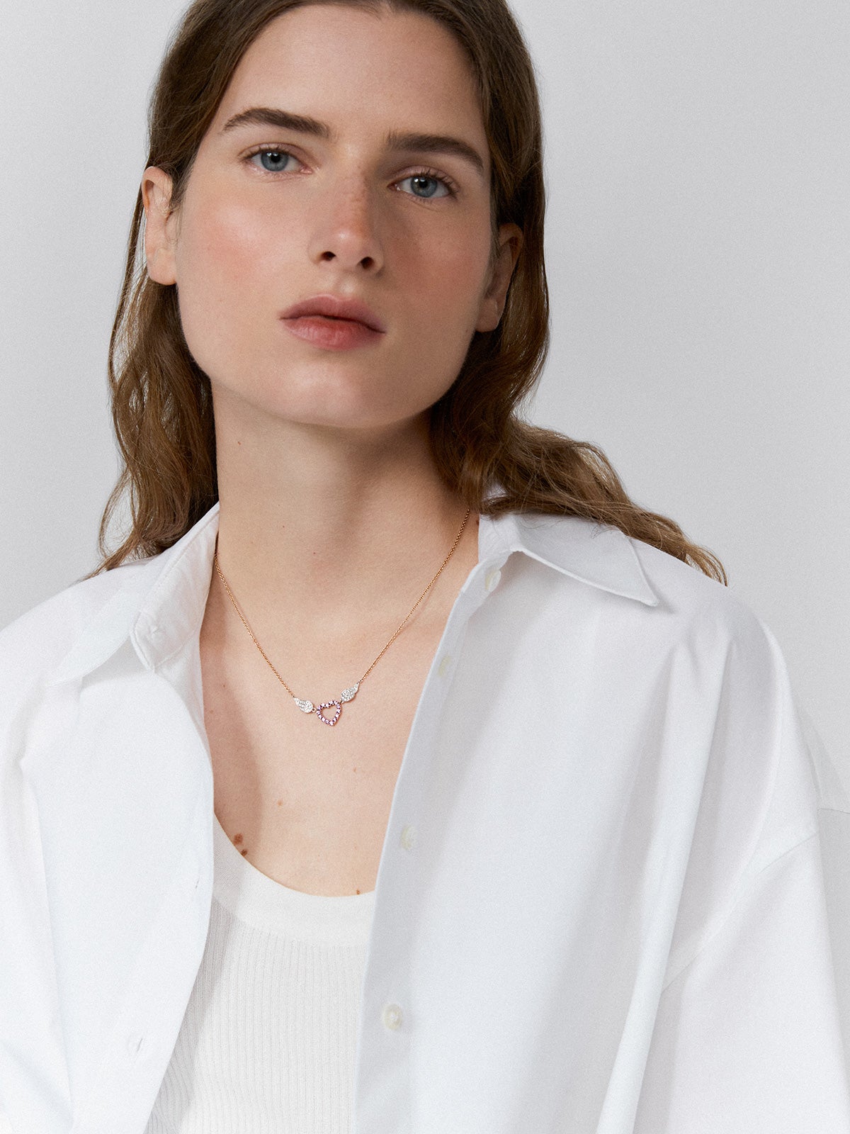 Colgante corazón con alas de oro rosa y oro blanco de 18kt con zafiros rosas y diamantes