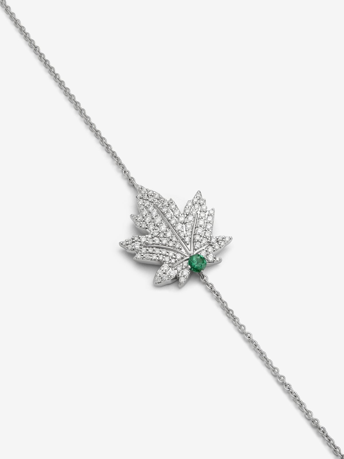18K white gold bracelet with a 0.1 ct central emerald, diamond pavé, and a maple leaf design