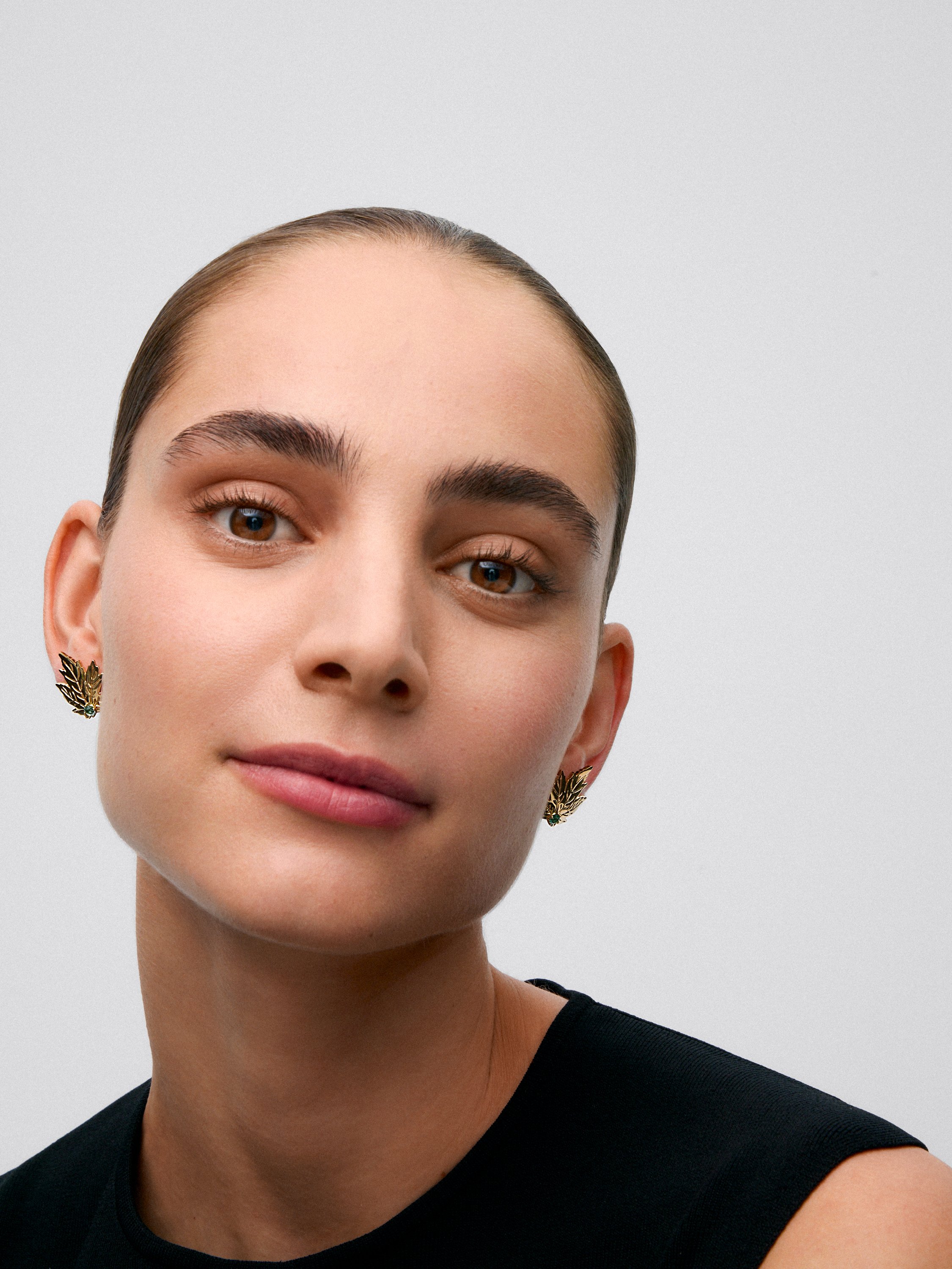 Pendientes de oro amarillo de 18K con 2 esmeraldas centrales en talla brillante con un total de 0,33 cts y forma de hoja de arce