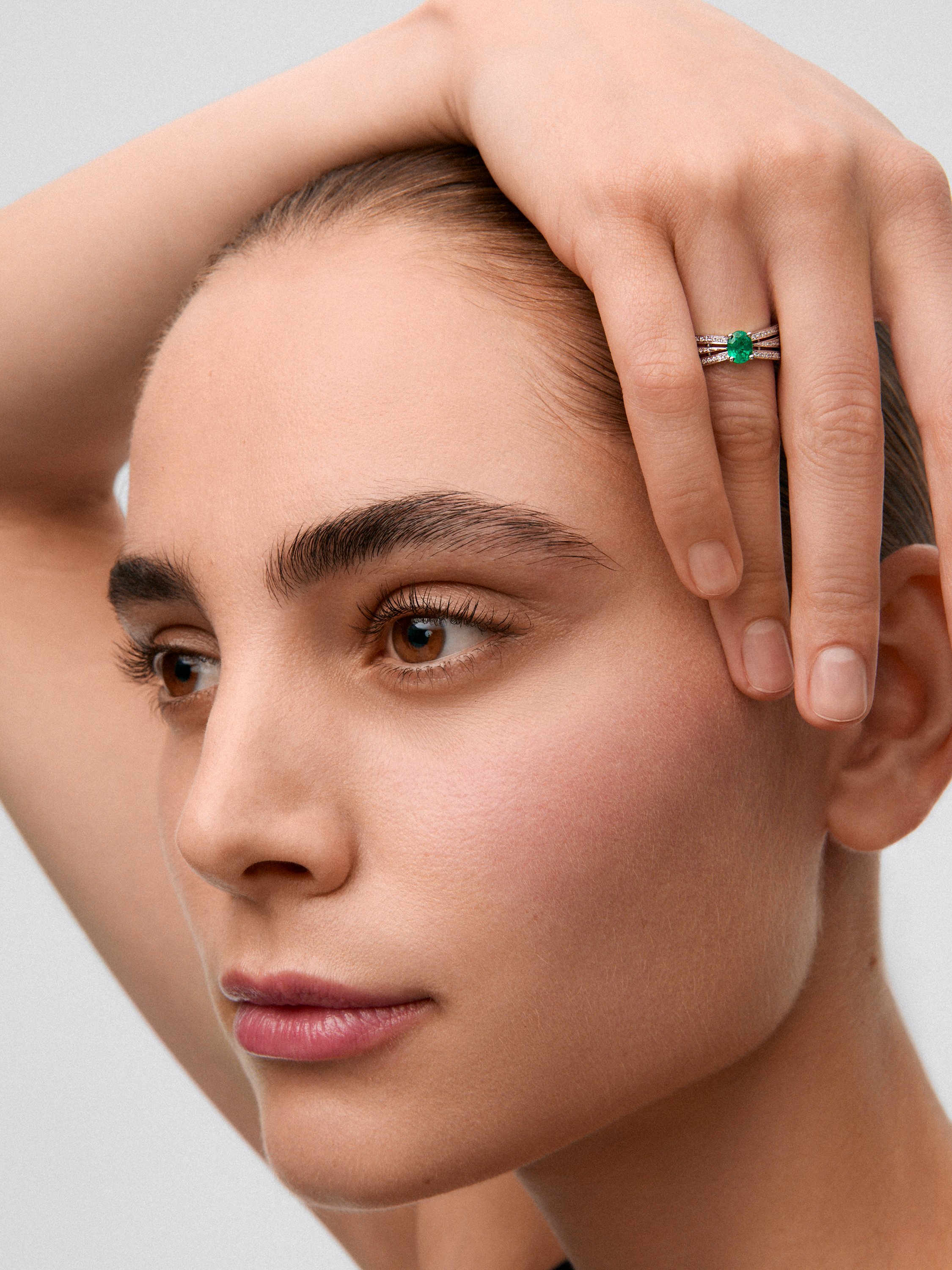 18K white gold multi-arm ring with oval-cut emerald ​​of 0.63 cts and brilliant-cut diamonds with a total of 0.43 cts