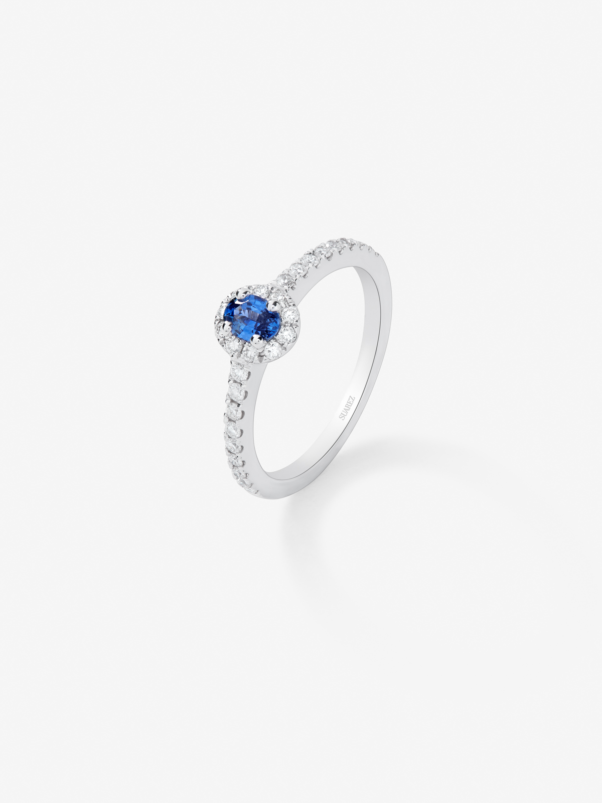 Anillo de oro blanco de 18K con zafiro azul en talla oval de 0,25 cts y diamantes en talla brillante de 0,24 cts