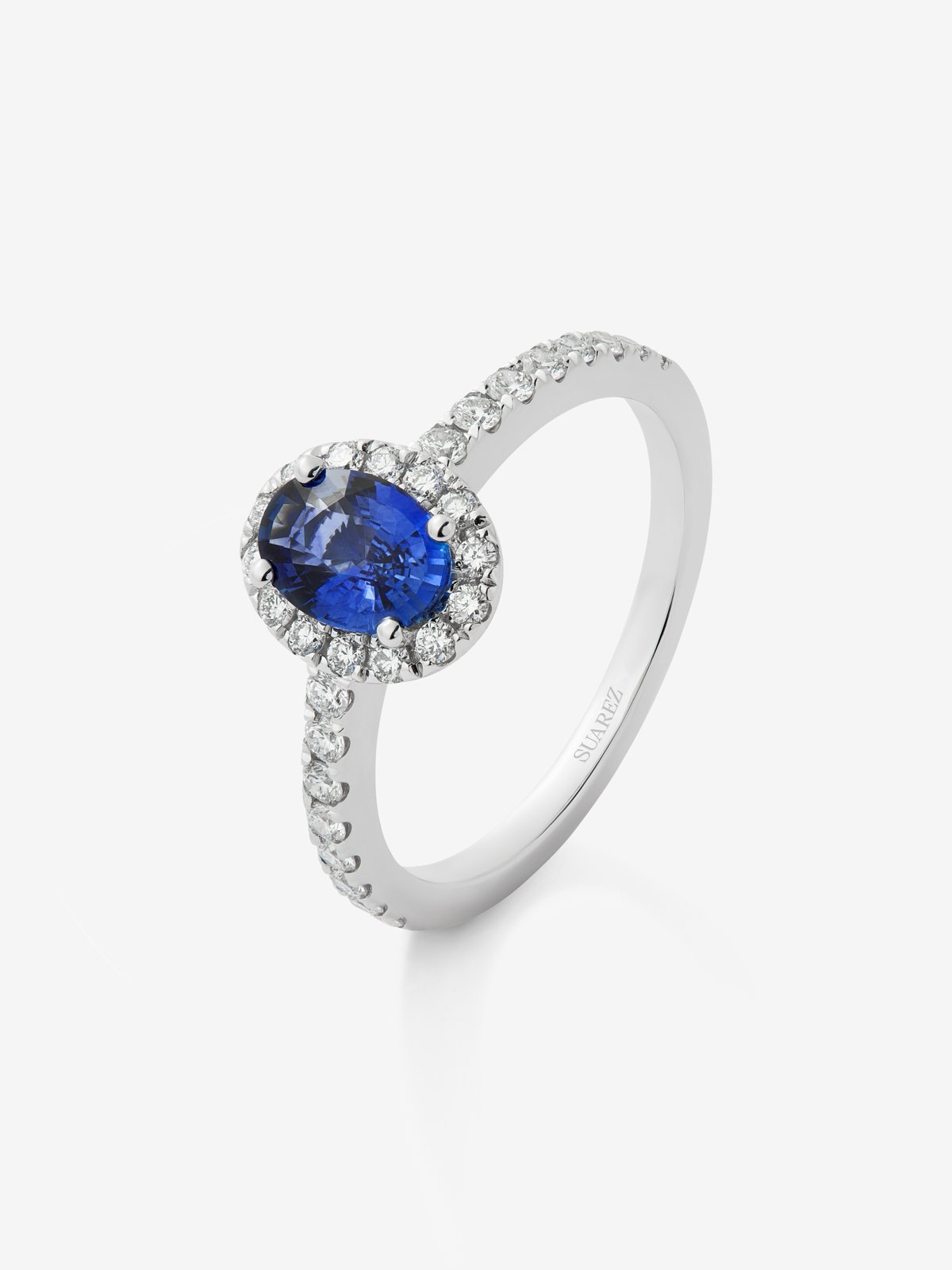 18K white gold ring with a 0.91 ct oval-cut blue sapphire and a brilliant-cut diamond border with a total of 0.37 cts