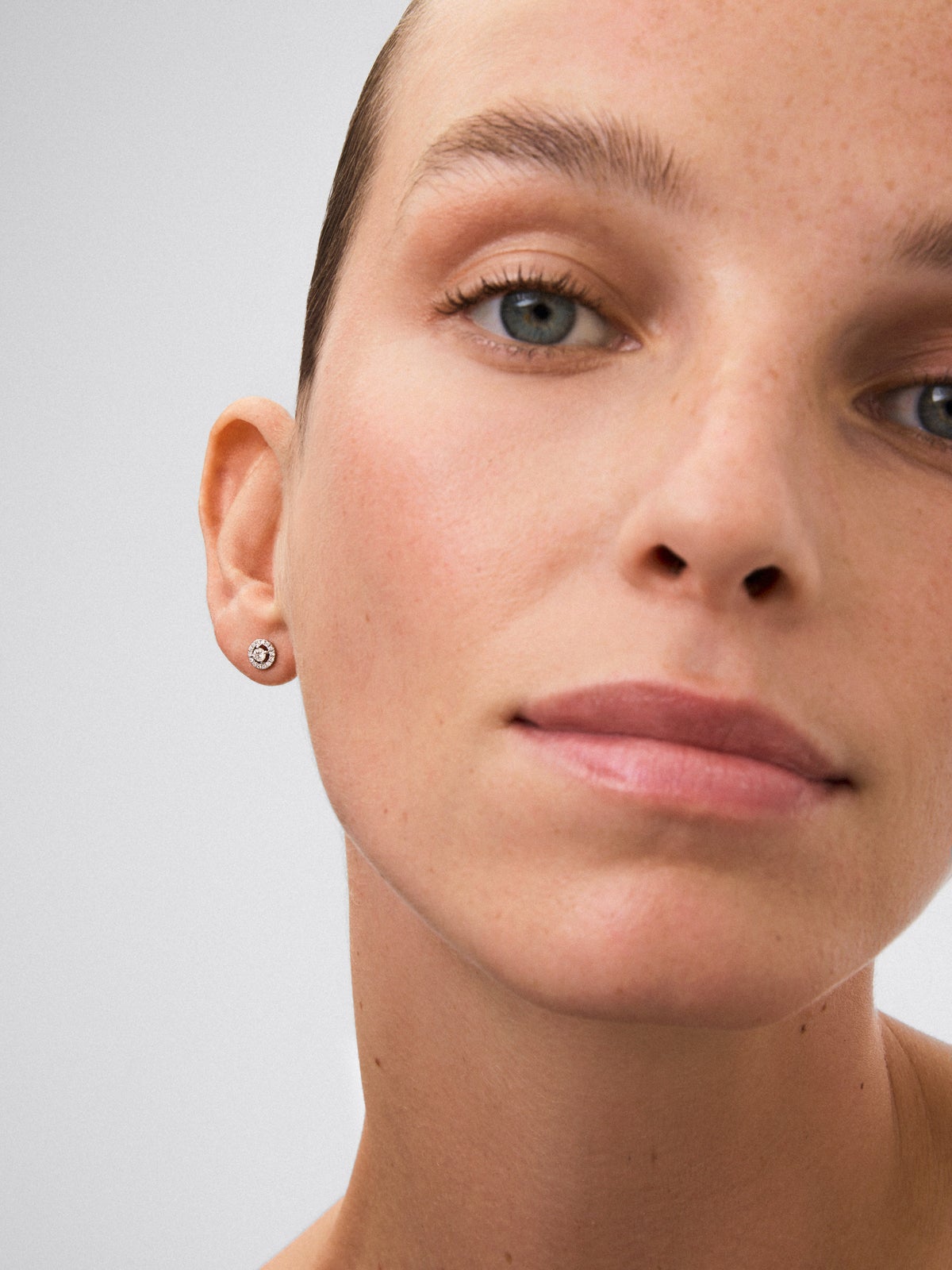 Pendientes de oro blanco de 18K con diamante solitario y orla de diamantes